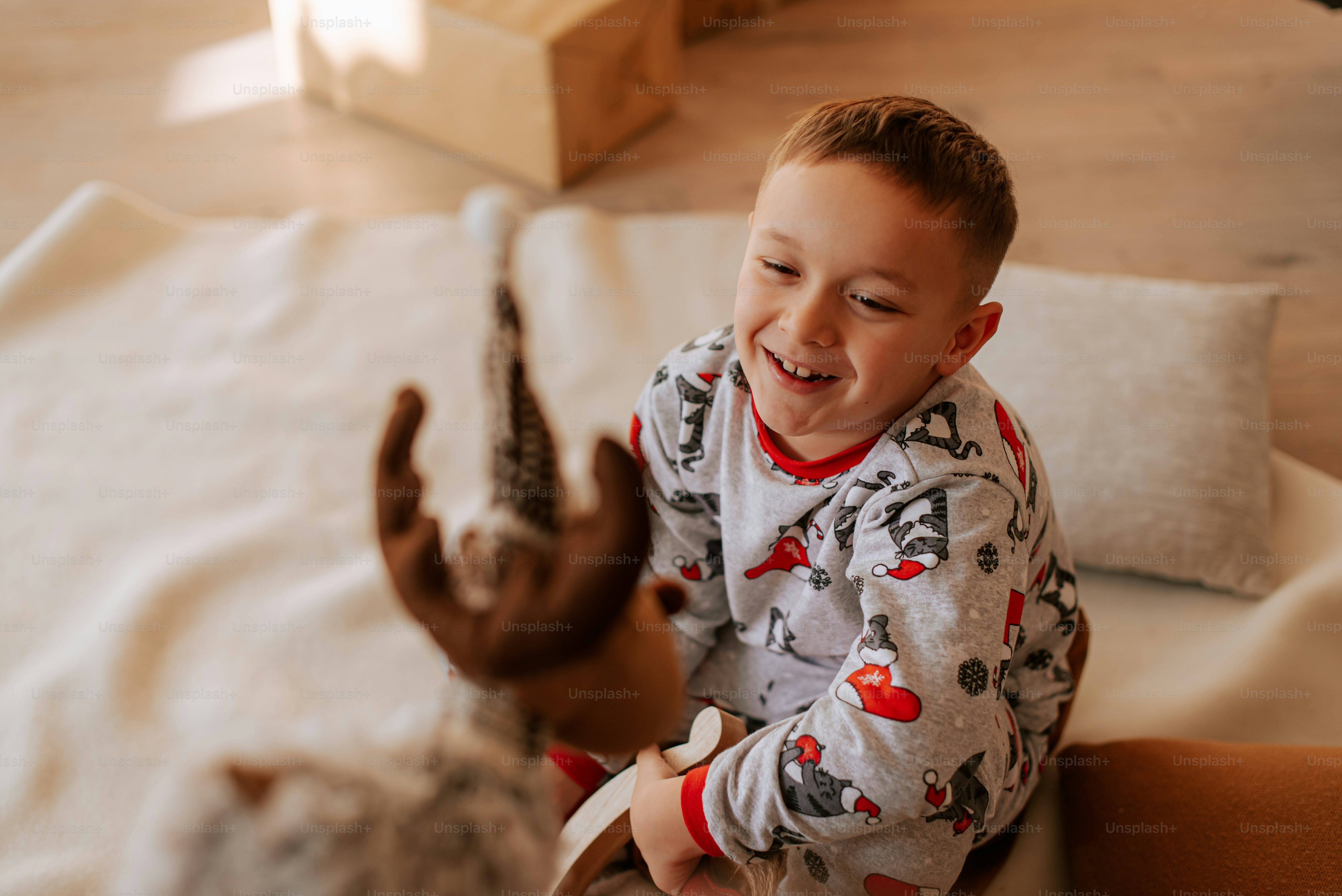 Un ragazzino che è seduto su un letto foto – Immagine di Natale su Unsplash, image size:3000x2003