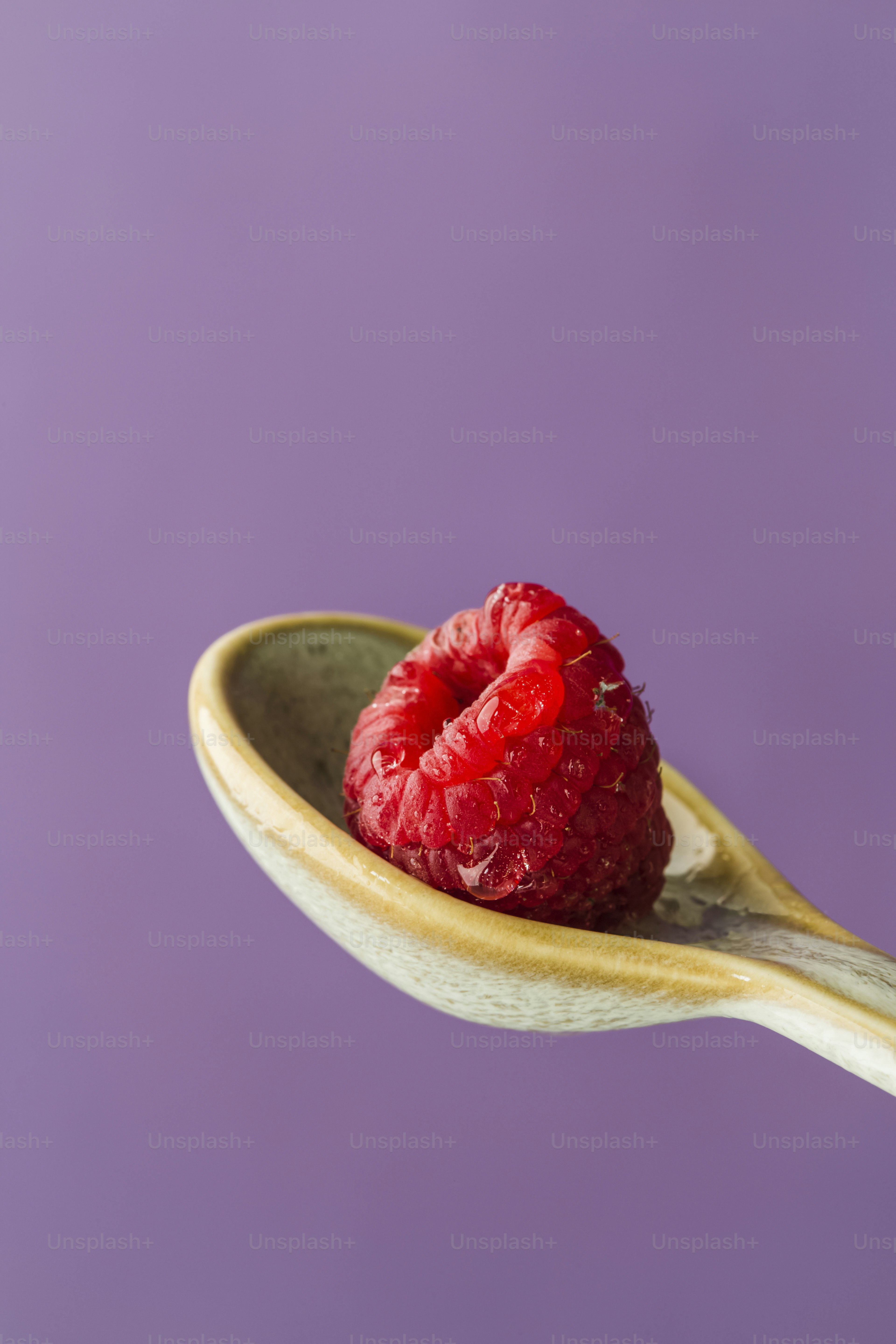 Una cuchara con una cuchara llena de frambuesas