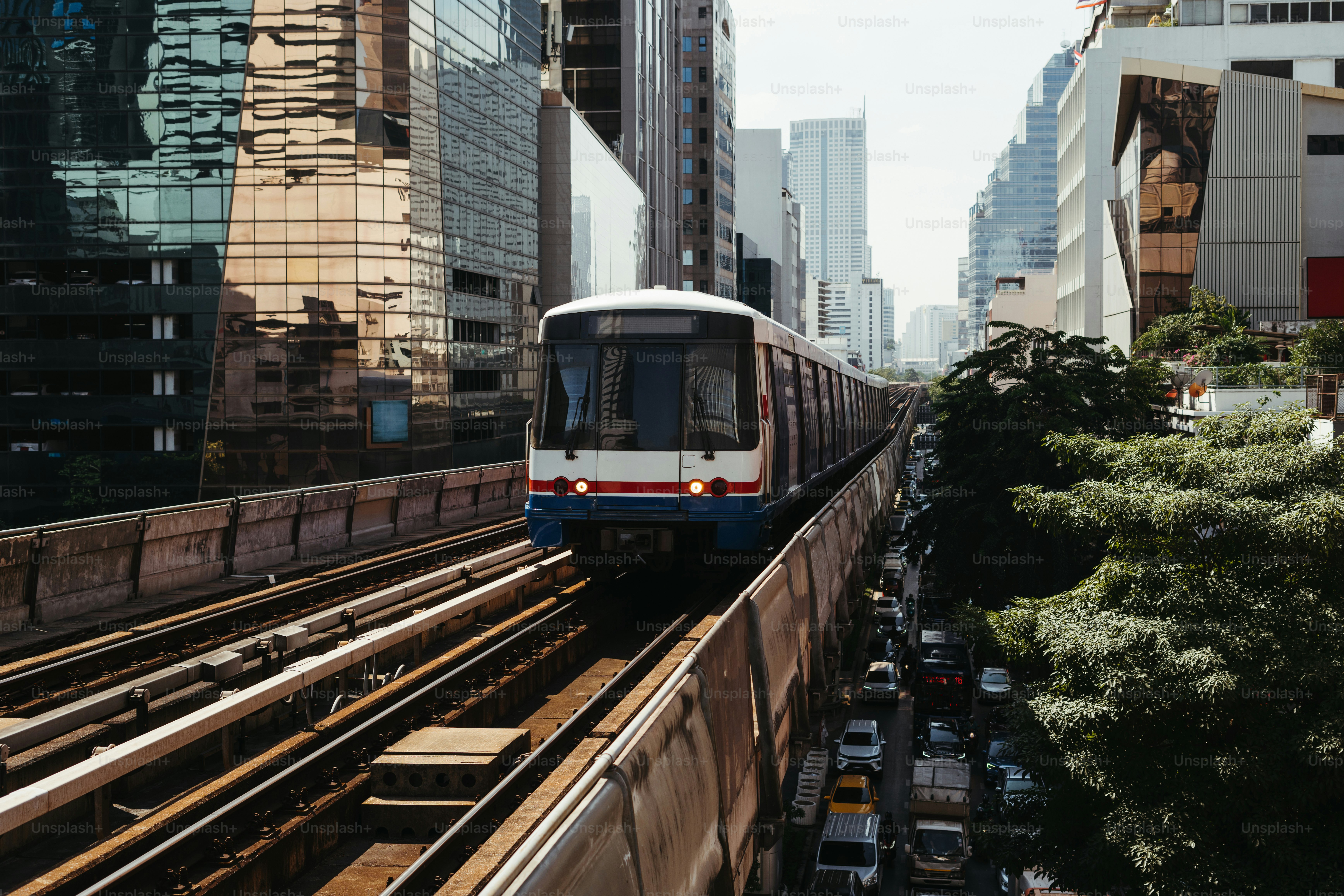 A train traveling through a city next to tall buildings