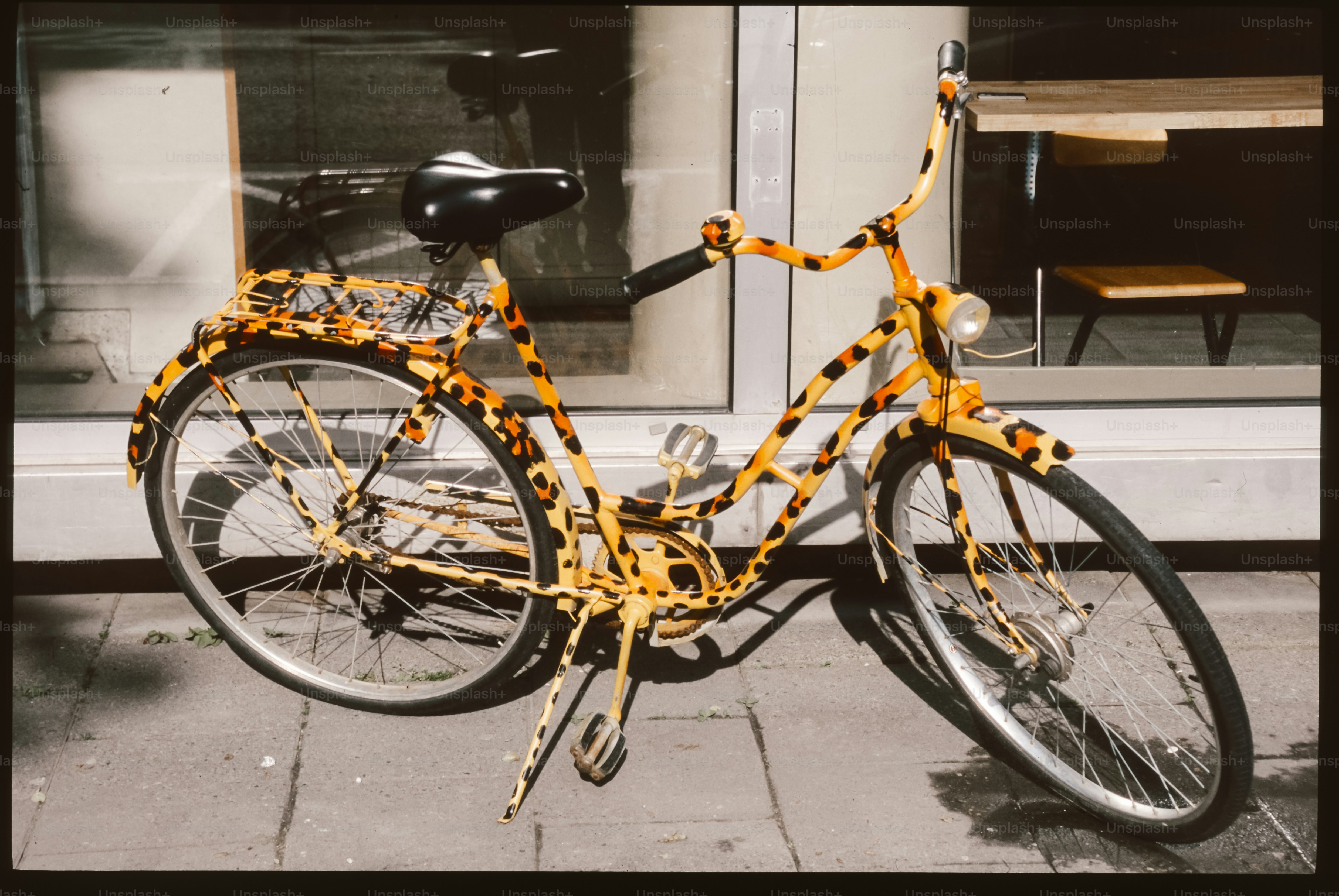 A yellow and black bicycle parked in front of a building