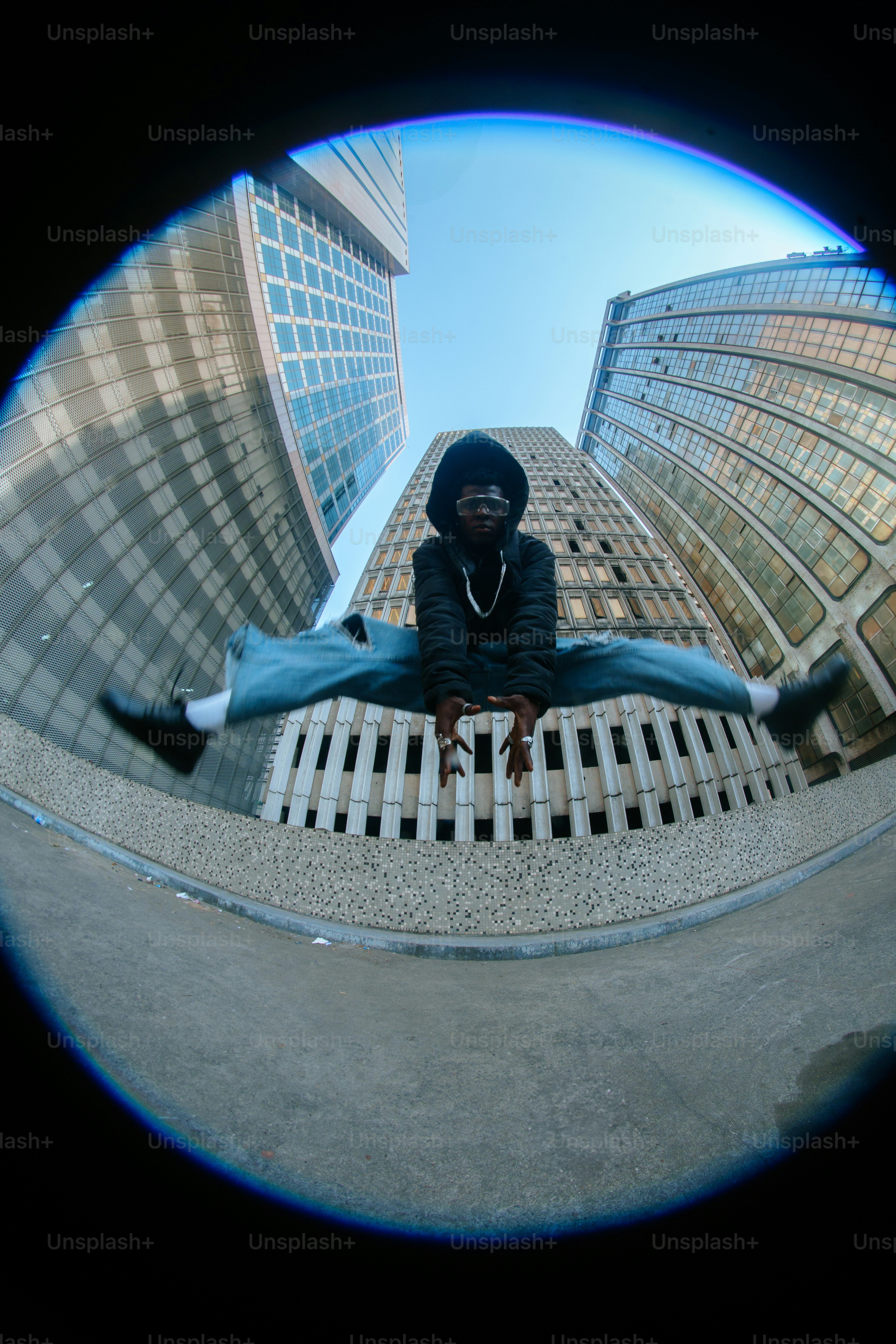 Eine Person, die auf einem Felsvorsprung vor hohen Gebäuden sitzt