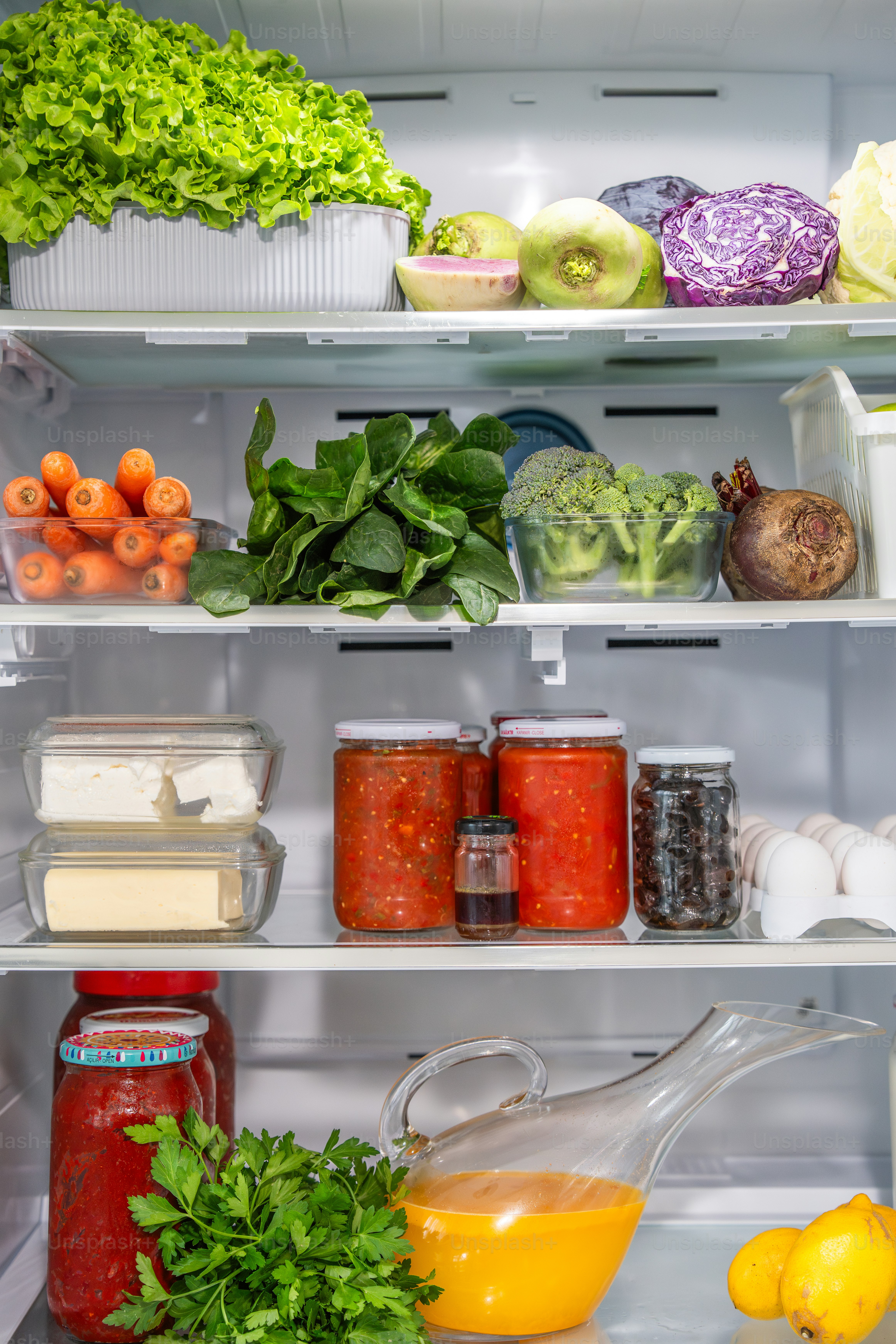 Un refrigerador lleno de muchos tipos diferentes de alimentos