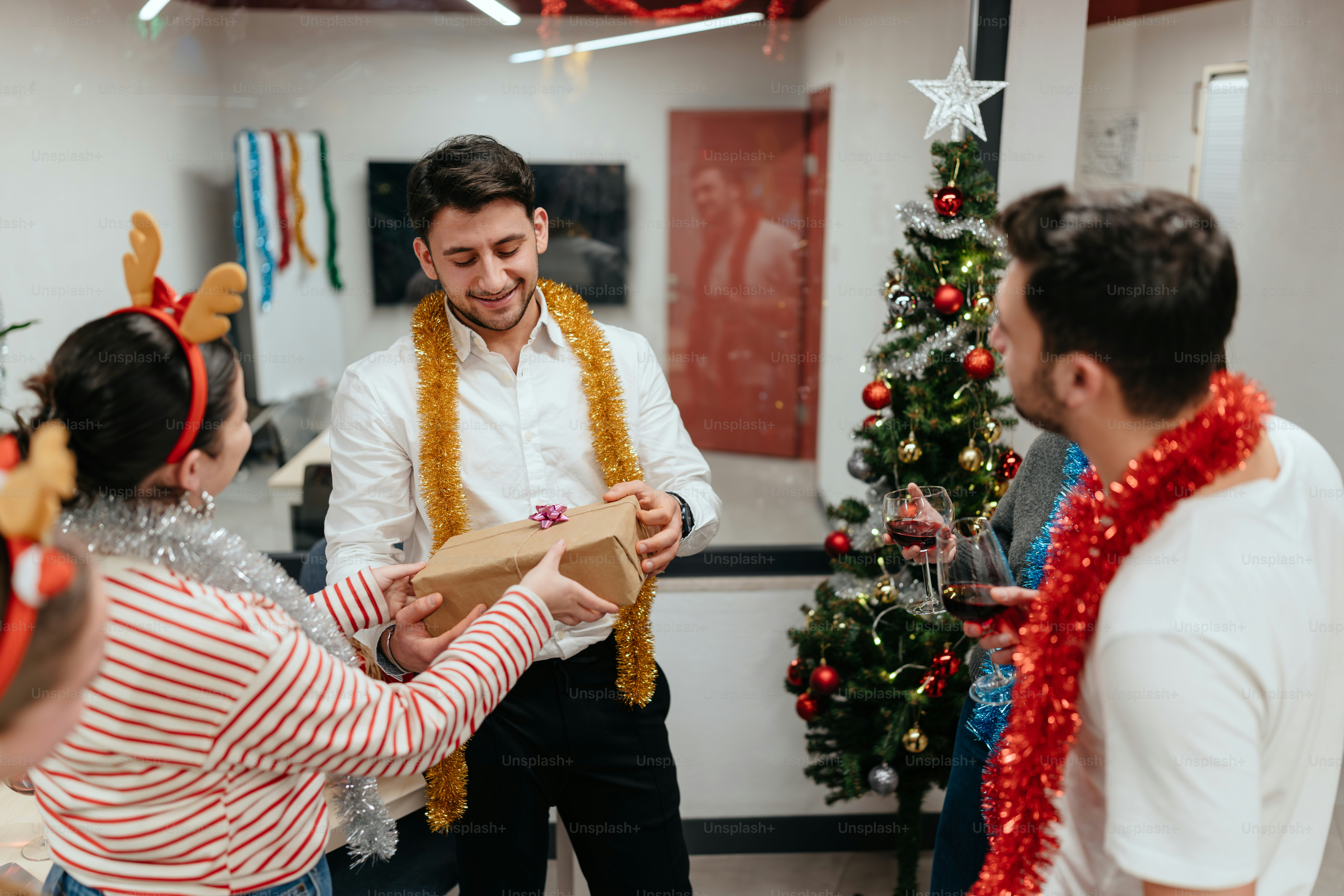 A group of people standing around a christmas tree photo – Office Image ...