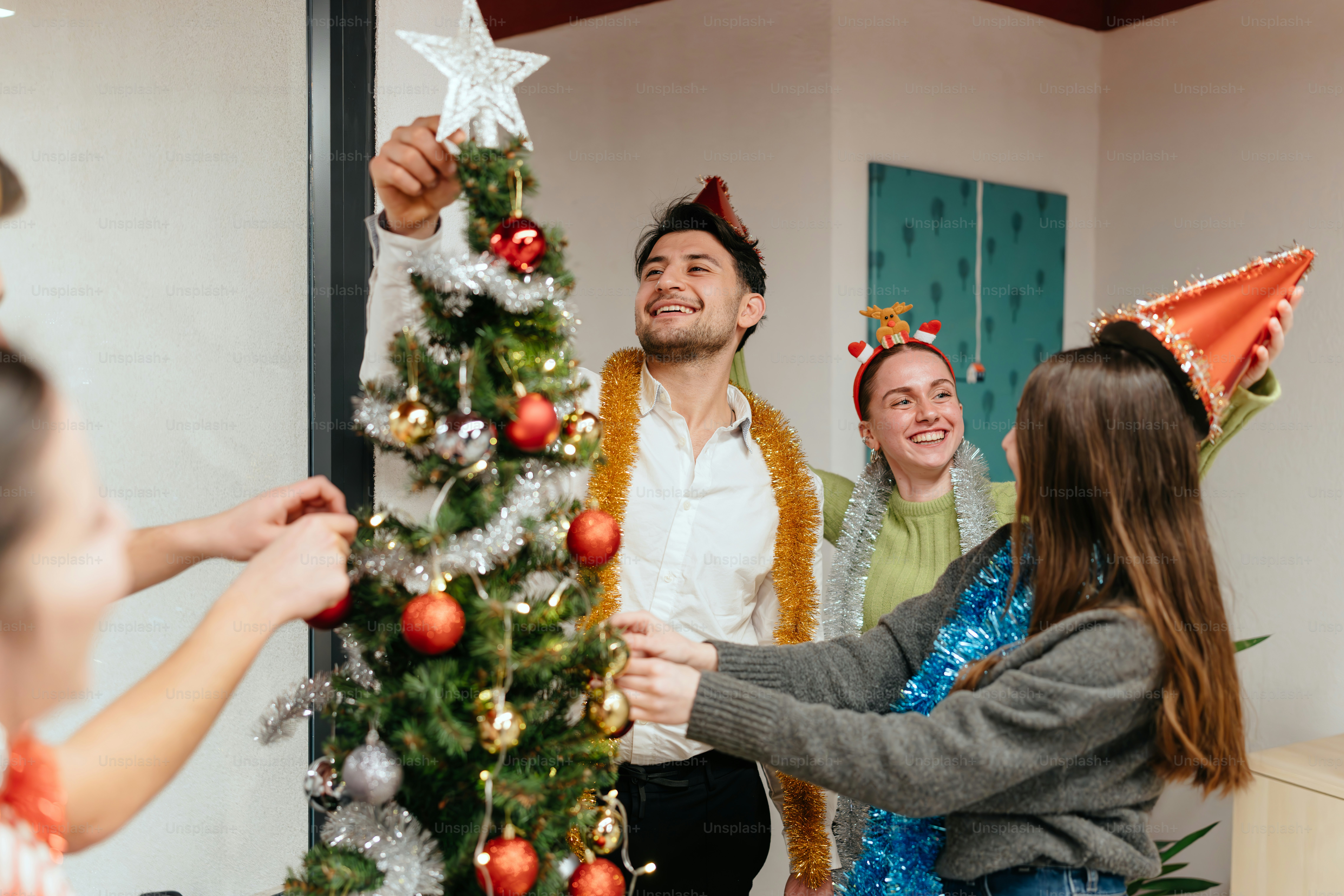A group of people standing around a christmas tree