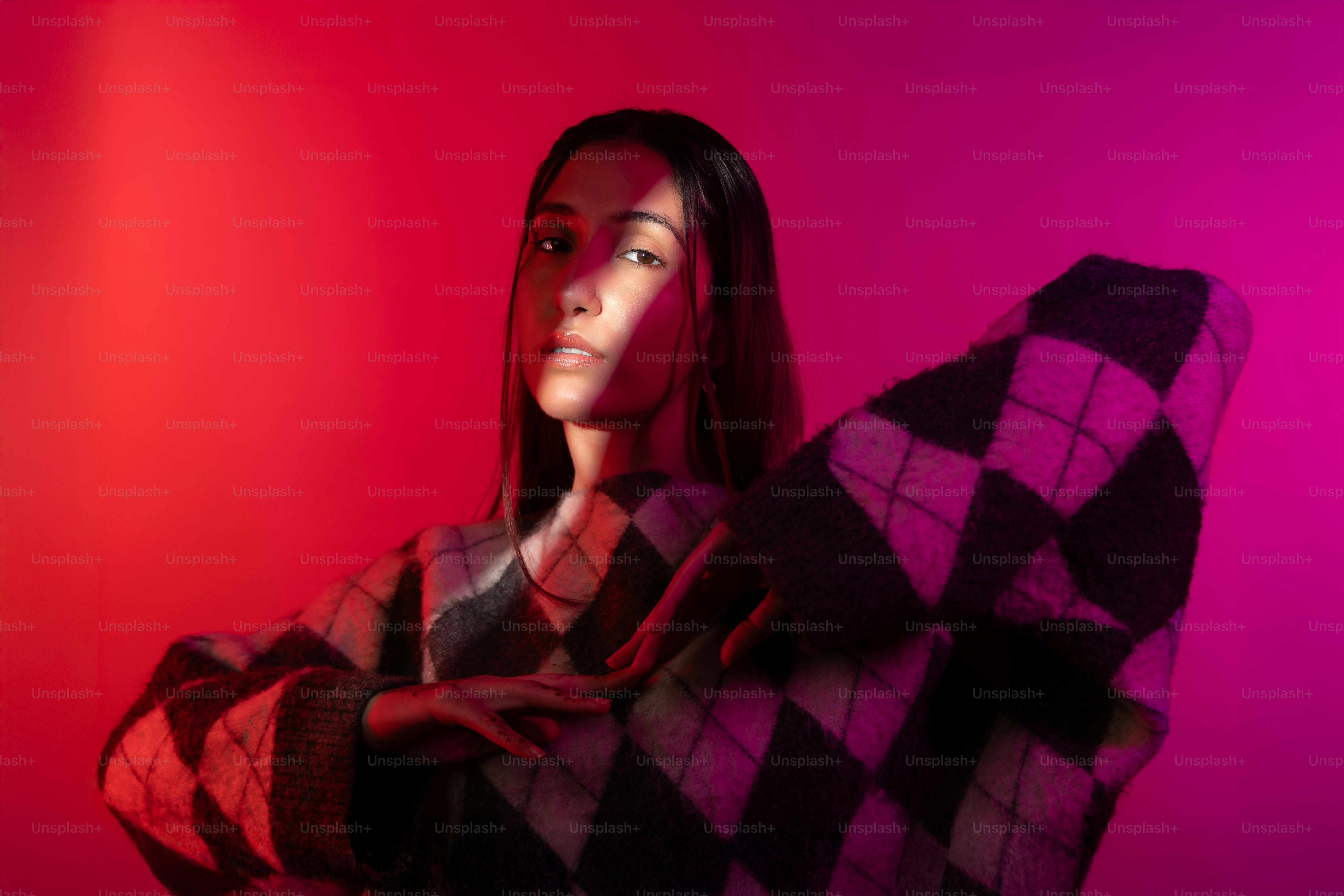 A woman standing in front of a red and purple wall photo – Portrait ...