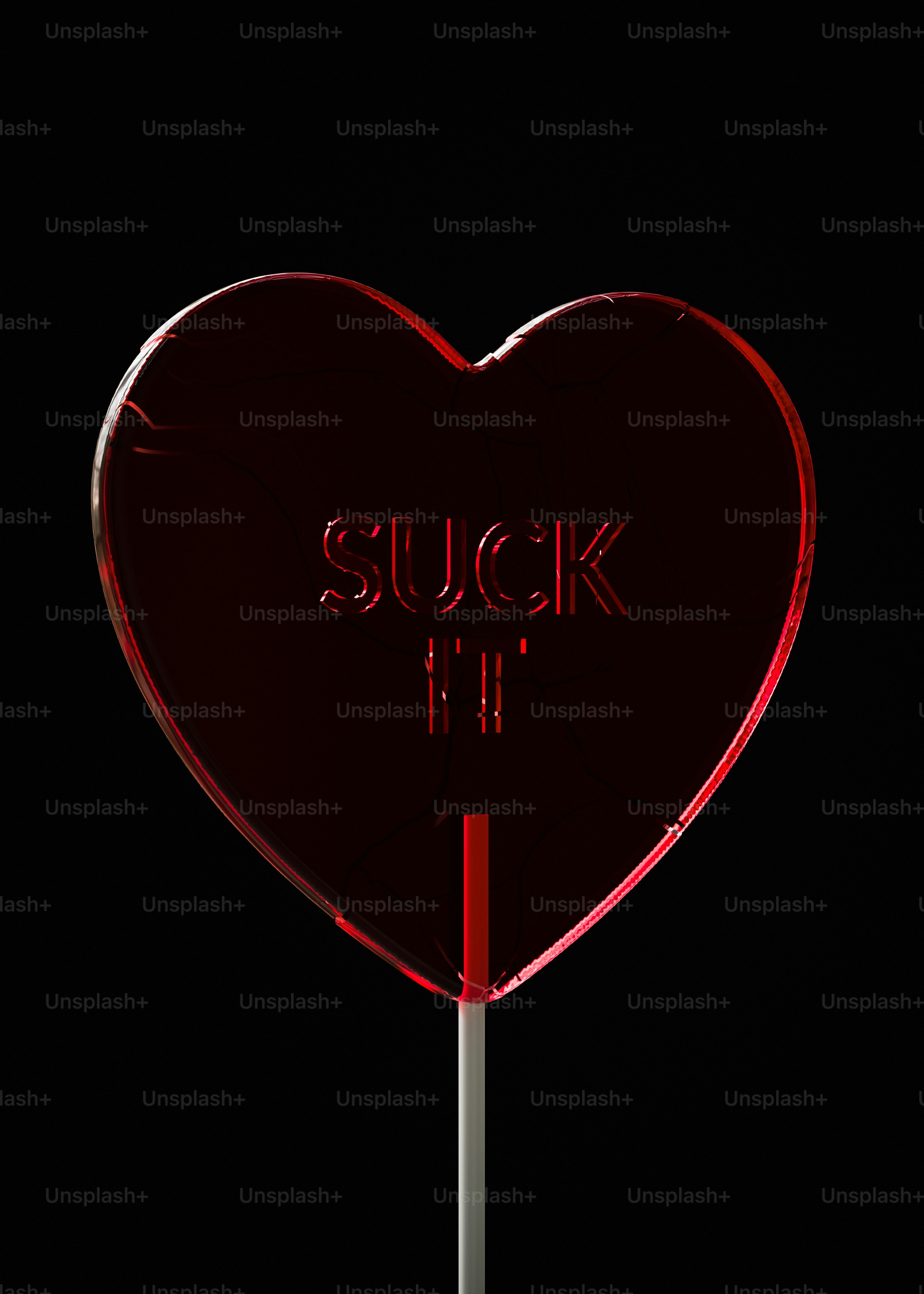 A red heart shaped lollipop with the words suck it on it