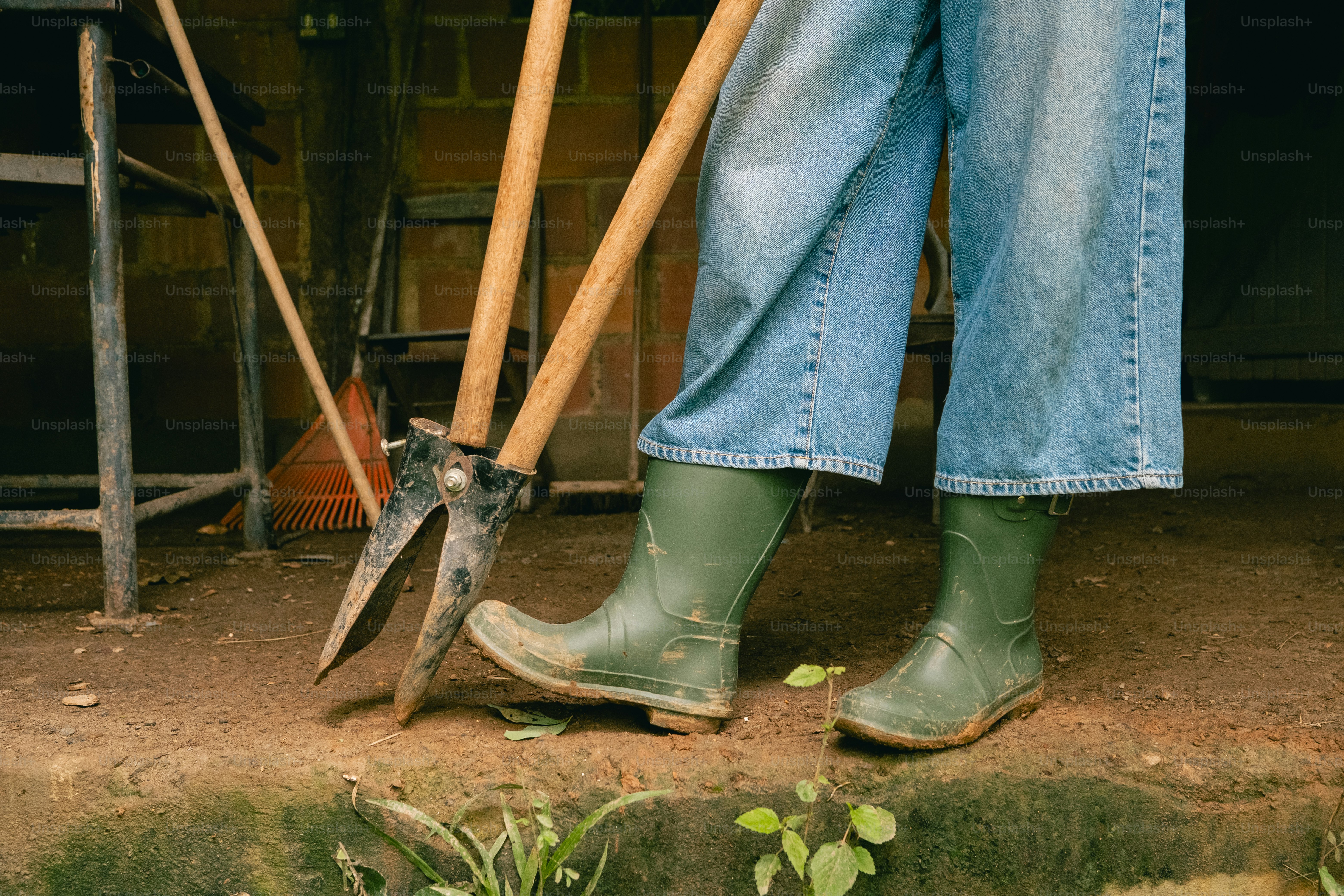 A person with a pair of boots and a shovel