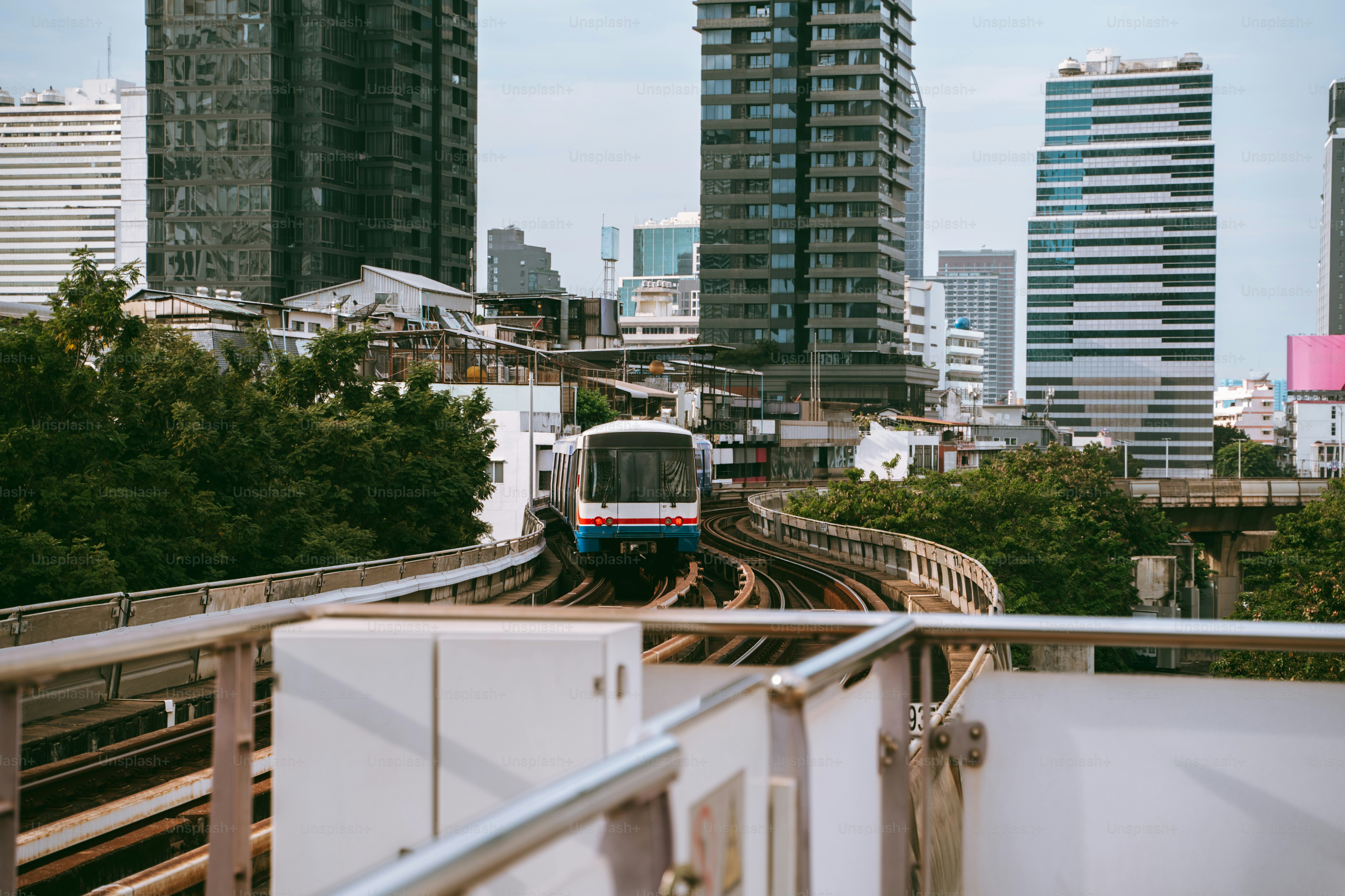 A train traveling through a city next to tall buildings