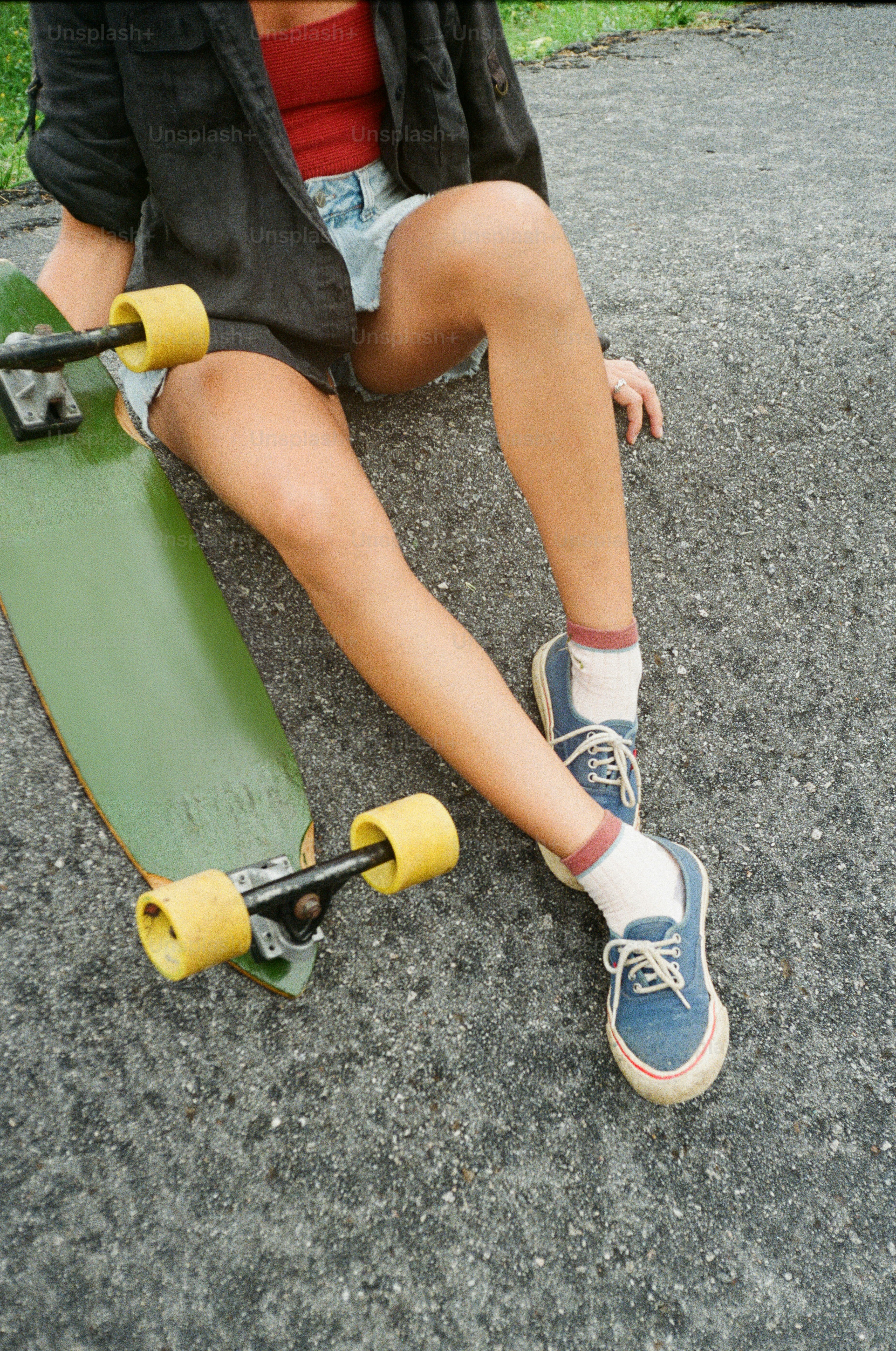 A person sitting on the ground with a skateboard
