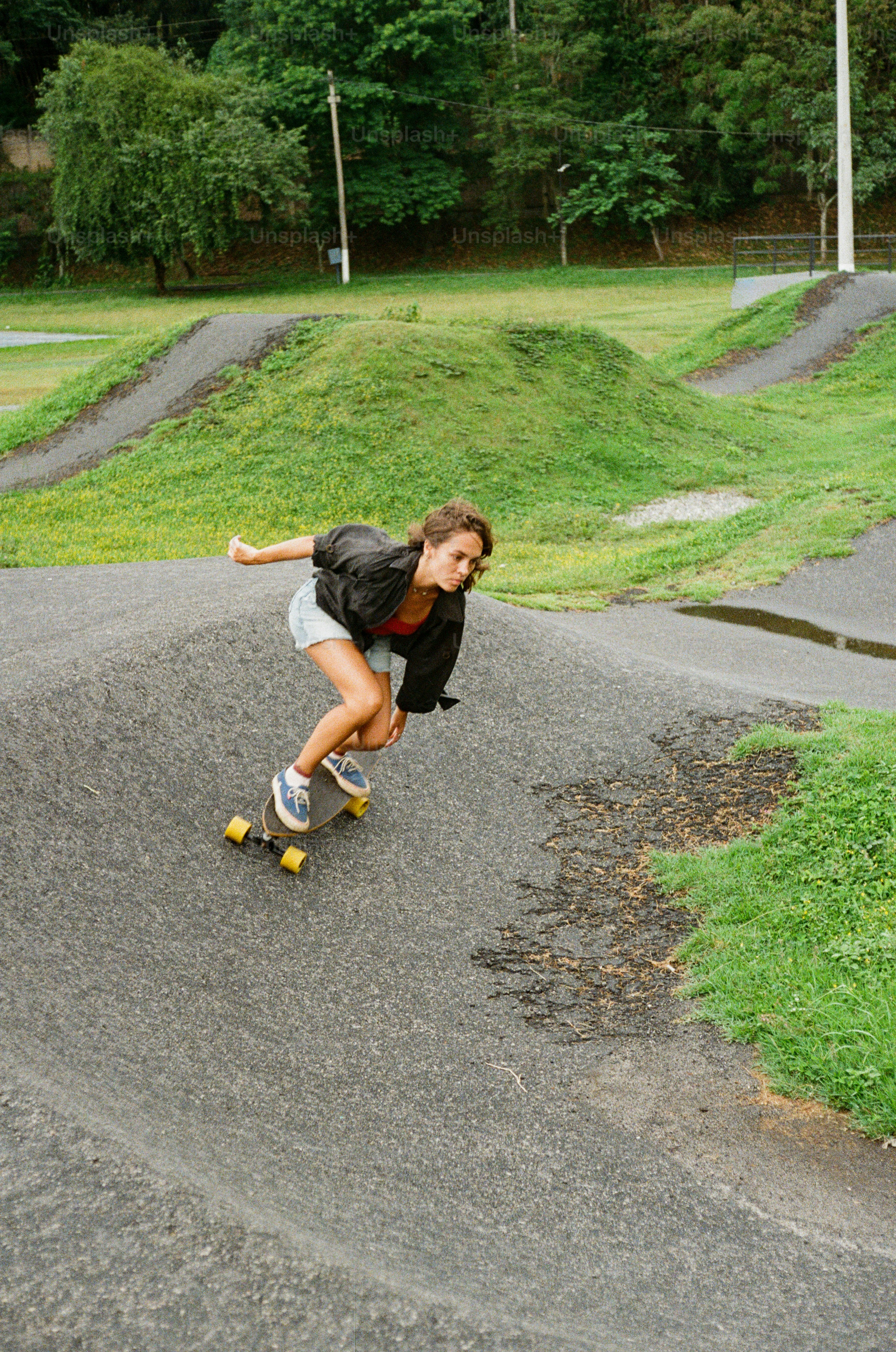 A woman riding a skateboard down a hill
