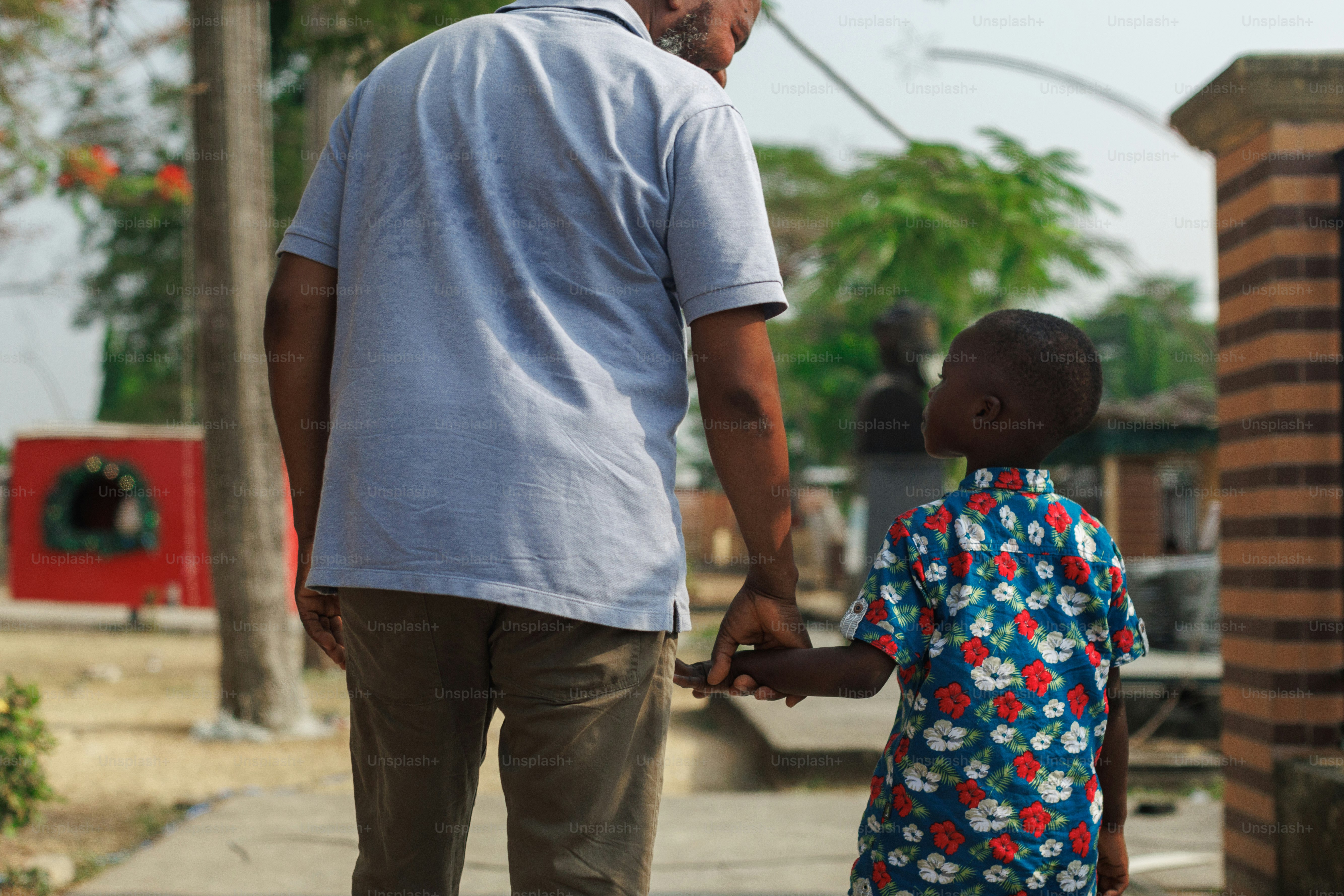A man holding the hand of a small child