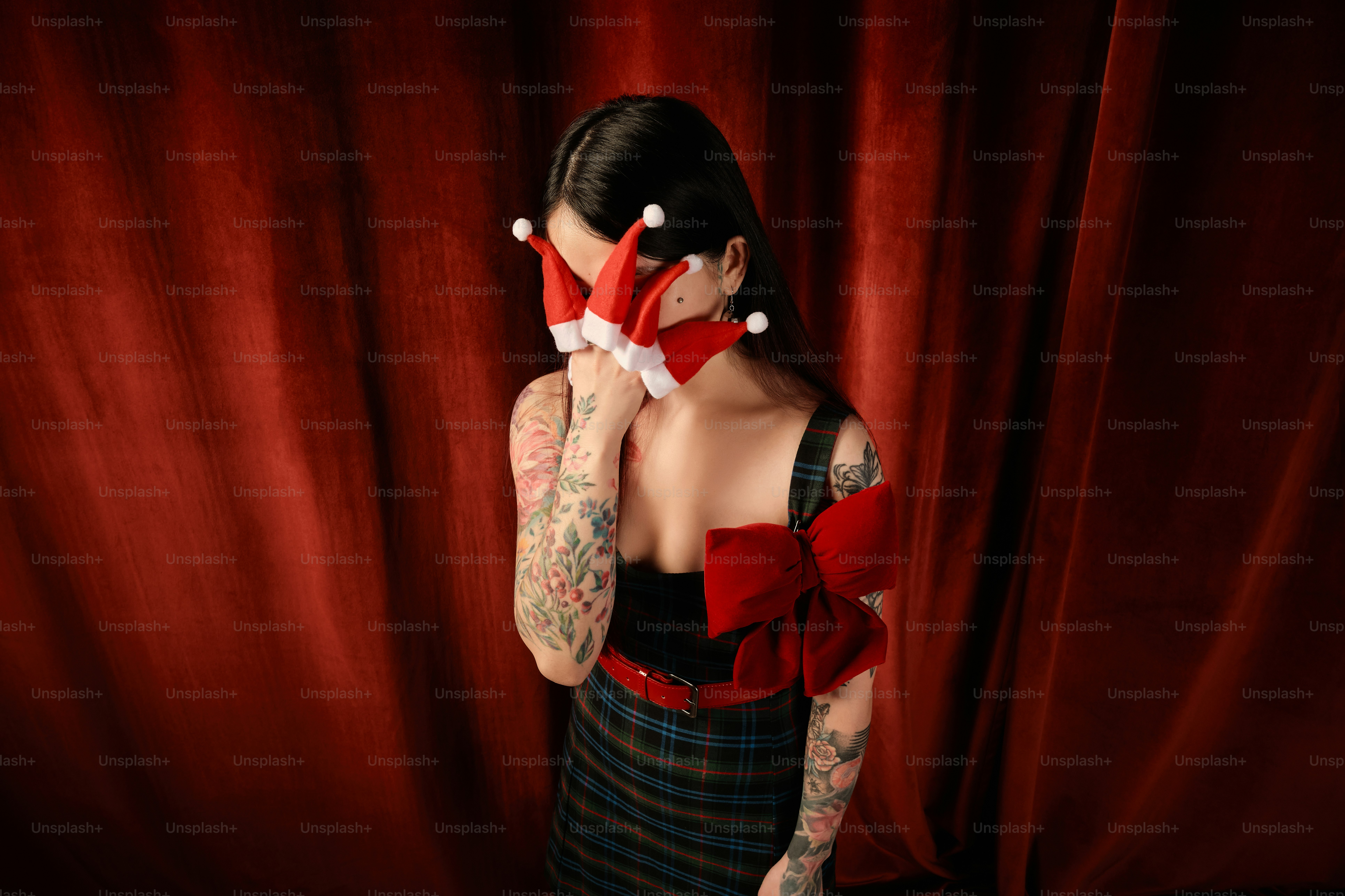 Seorang wanita bergaun merah dan hitam memegang gunting