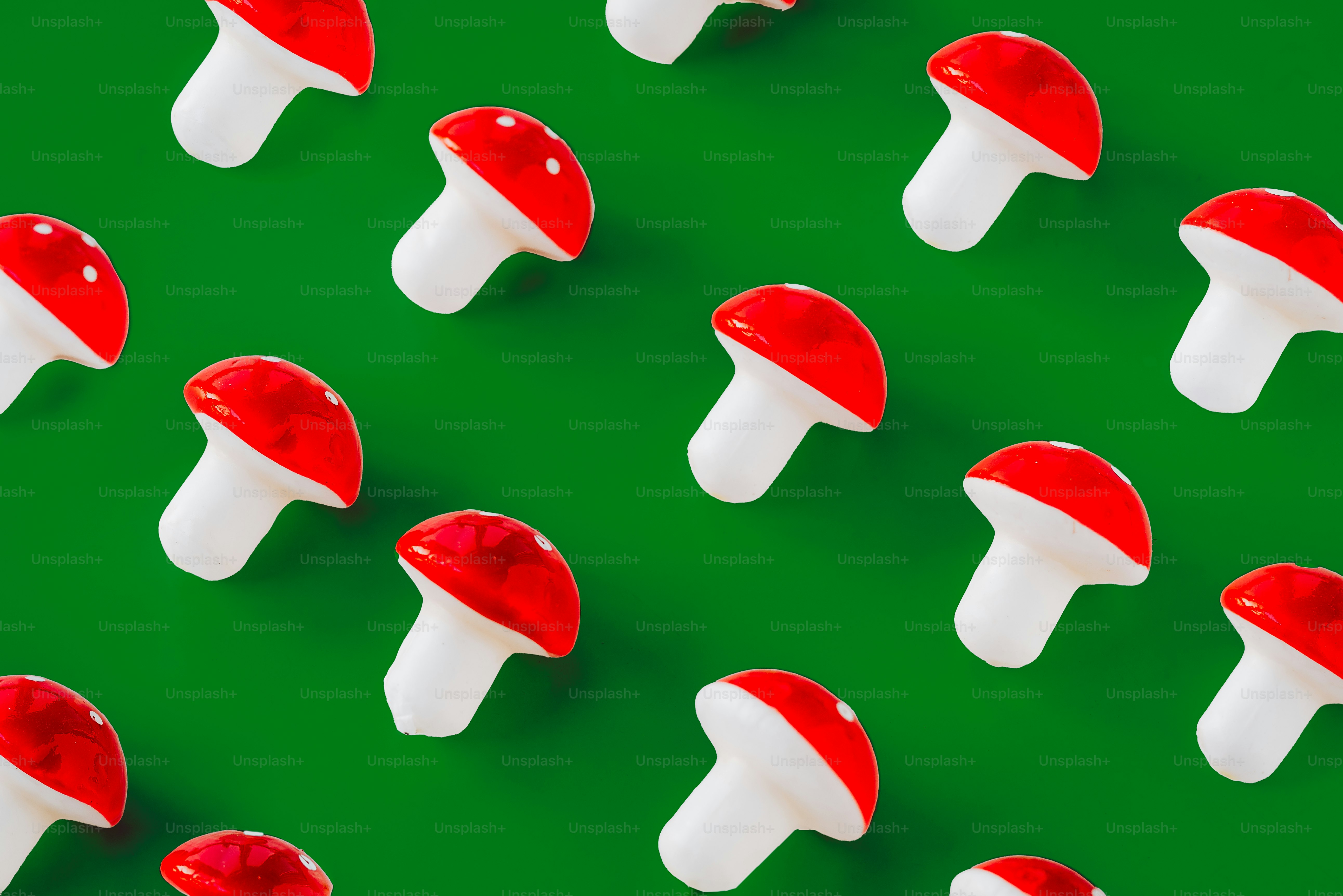 緑の背景に赤と白のキノコのグループ