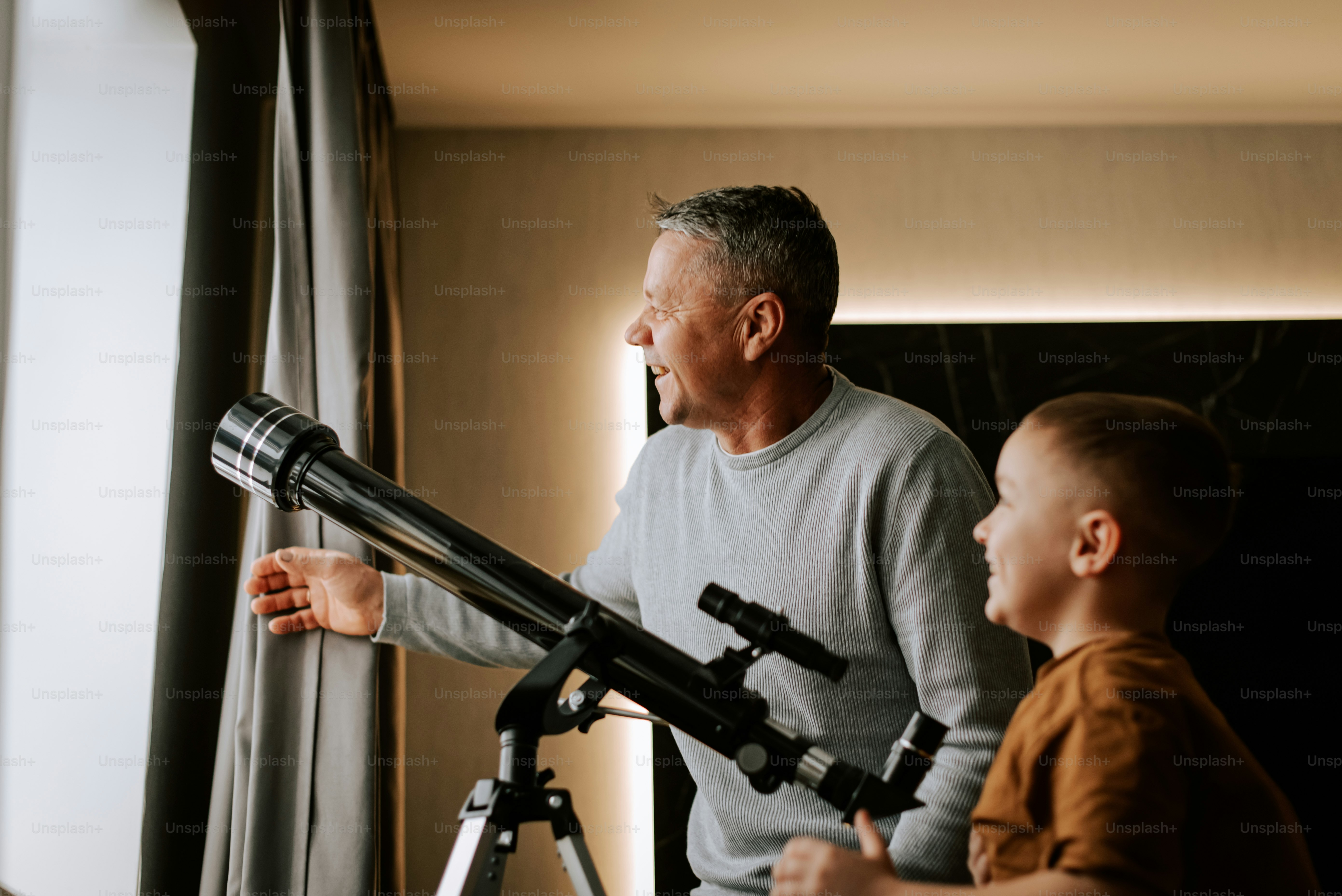 A man and a boy looking through a telescope