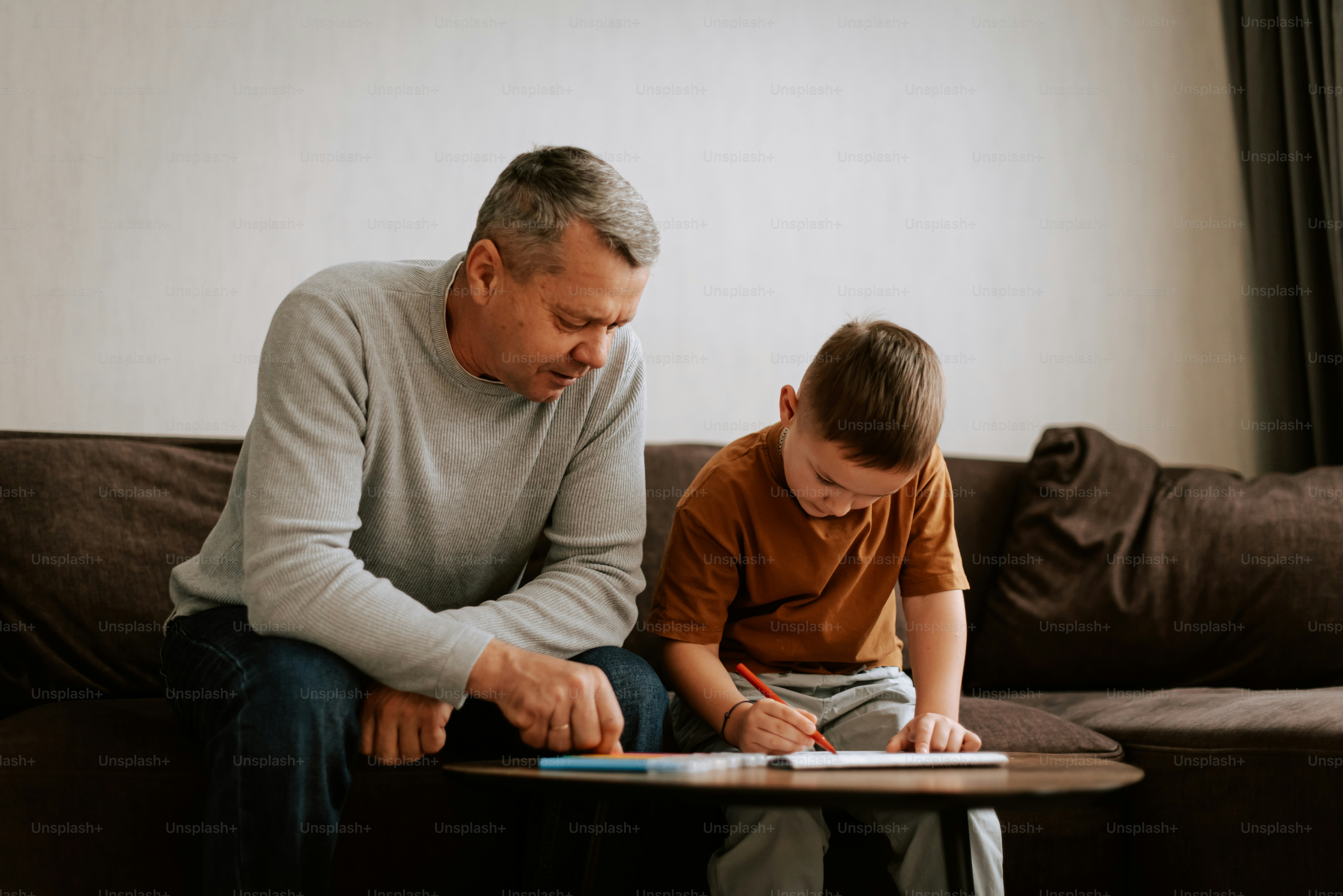 An older man and a young boy sitting on a couch