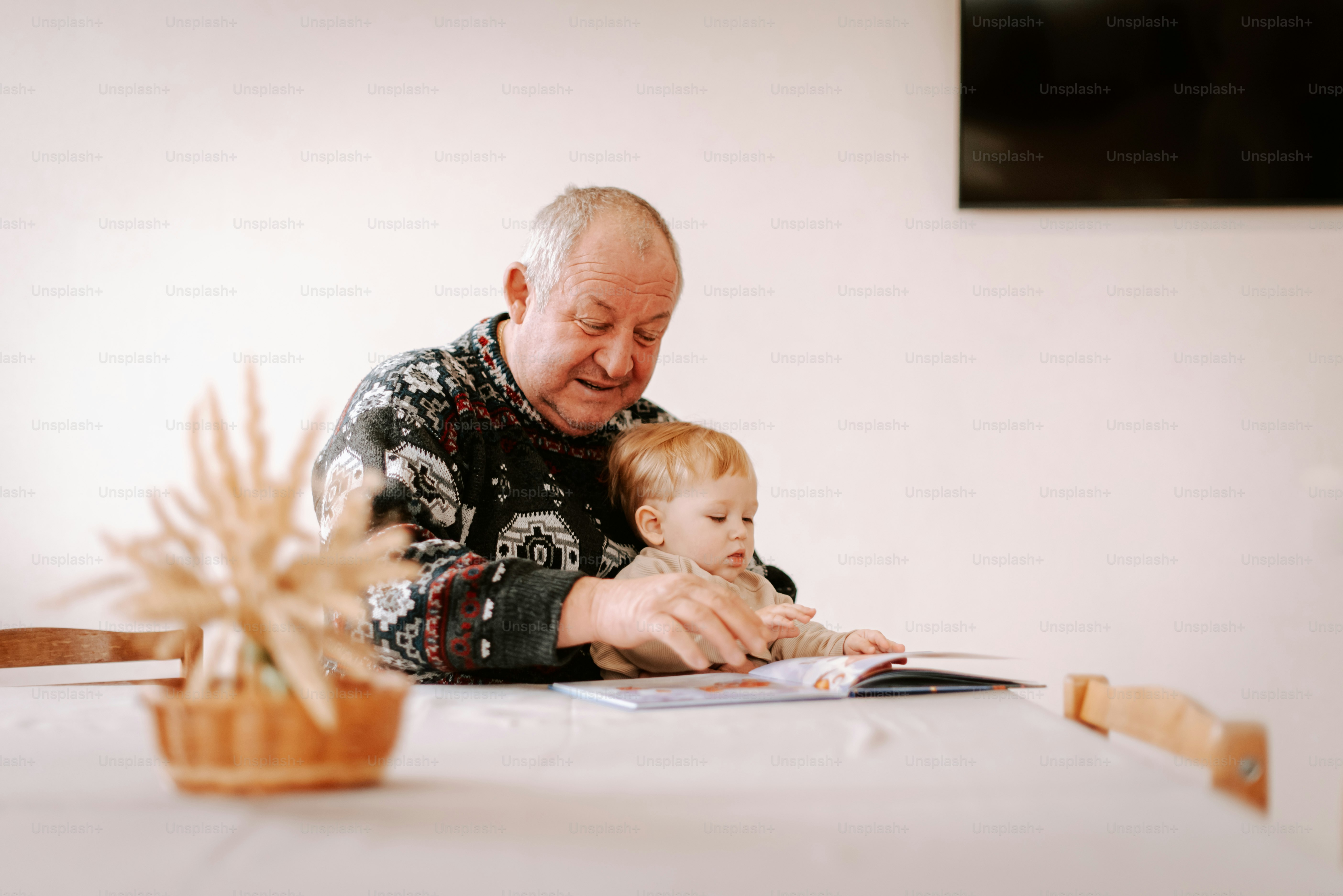 A man sitting at a table holding a baby