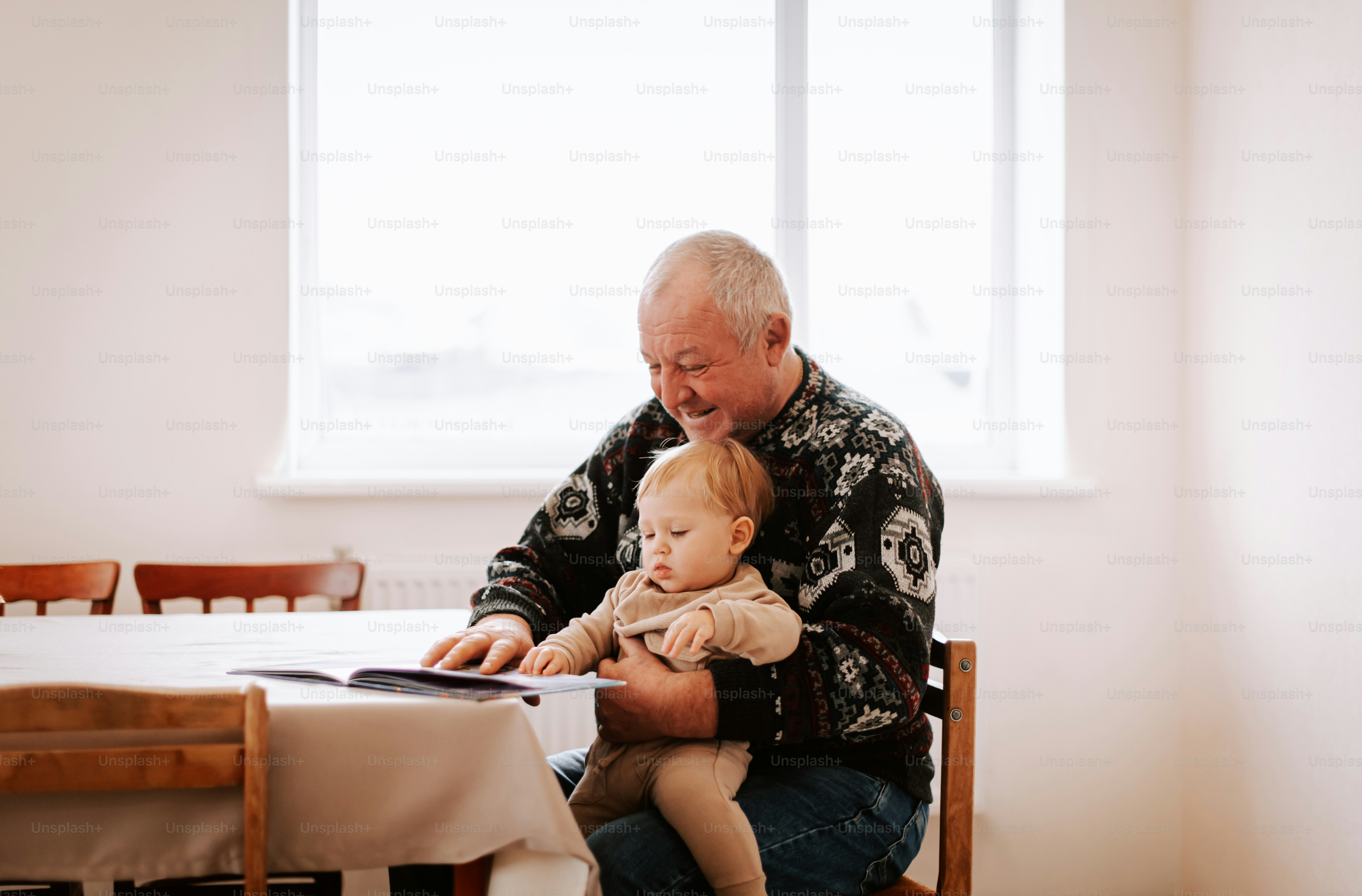 A man sitting at a table holding a baby