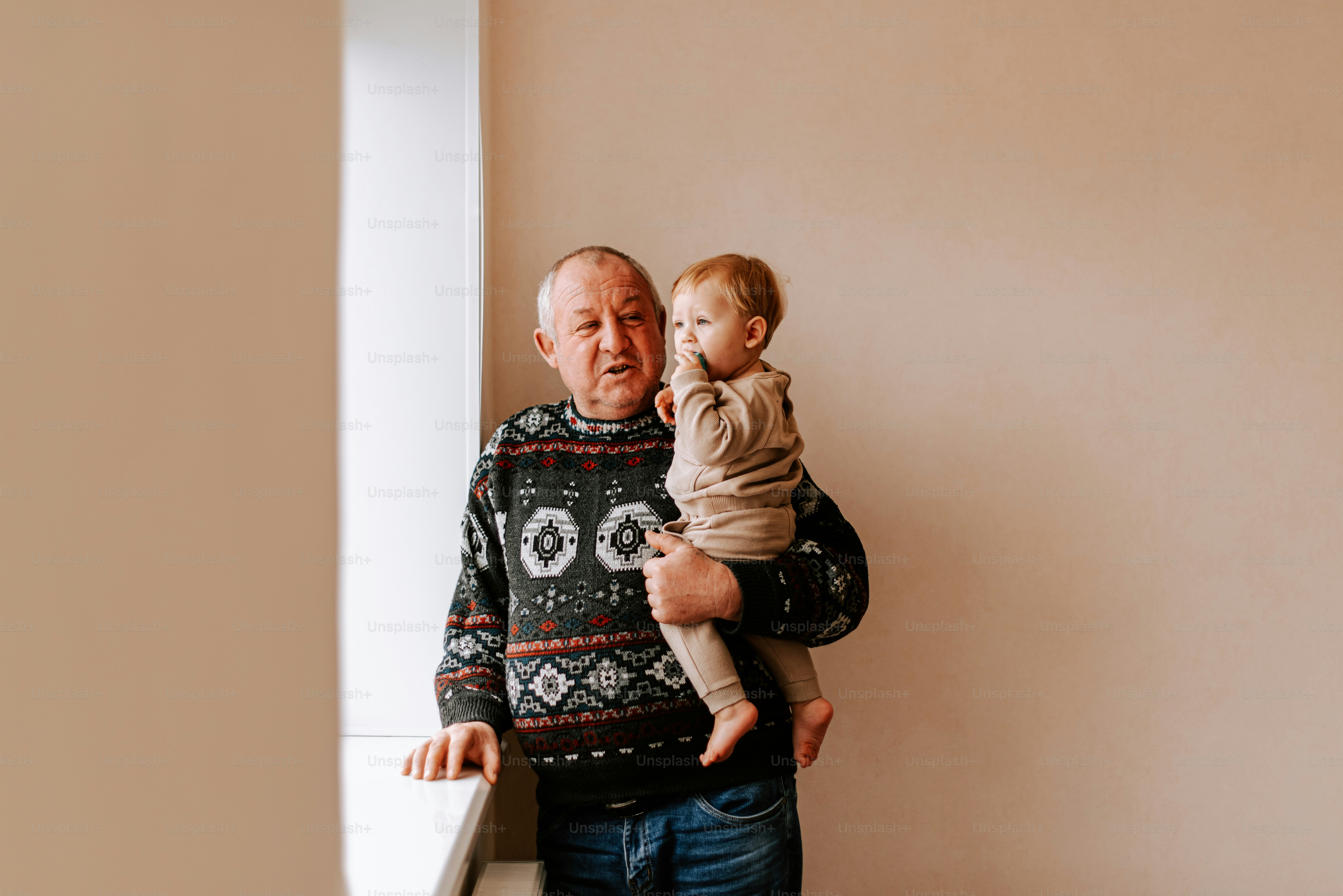 An older man holding a baby in his arms