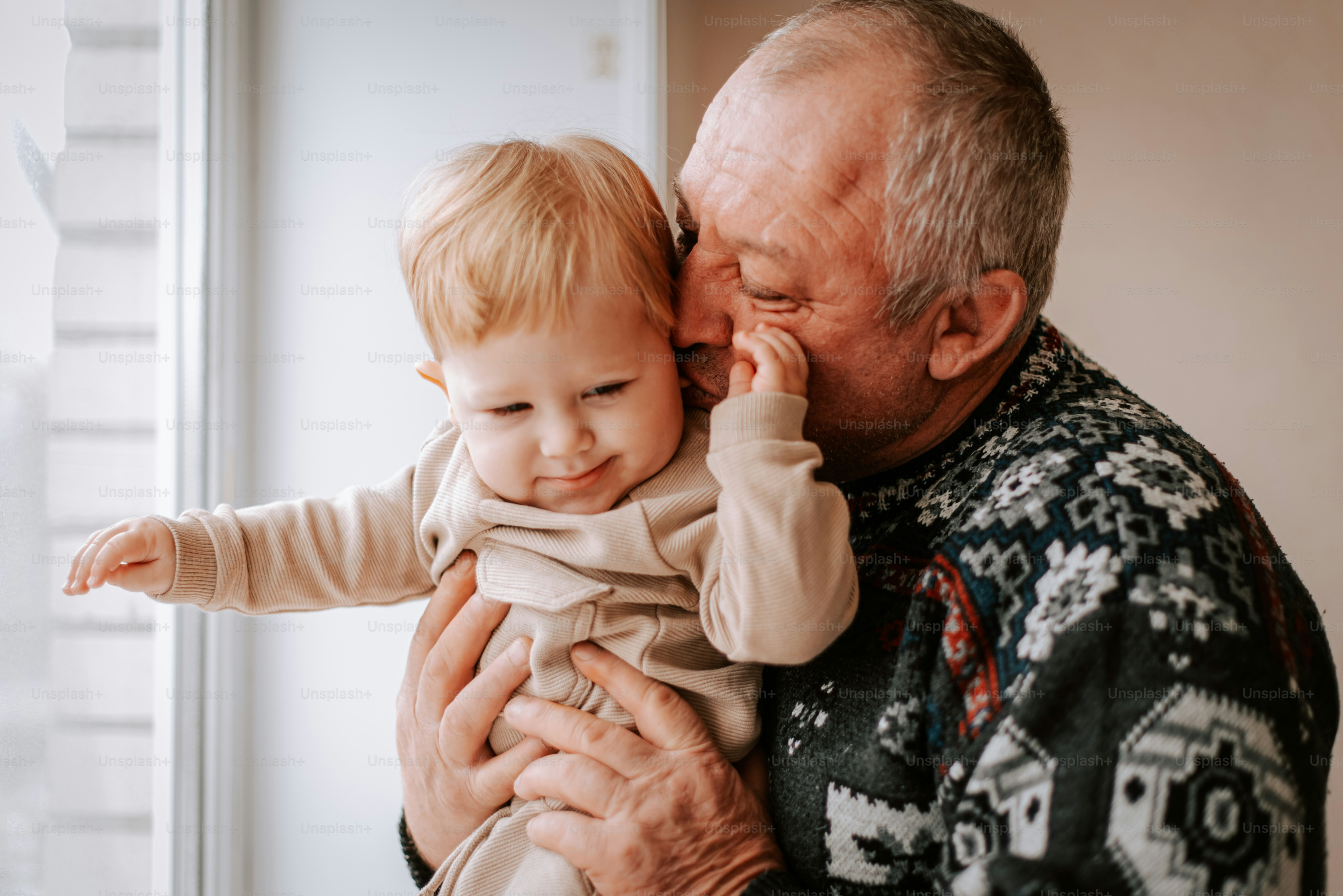 An older man holding a baby in his arms