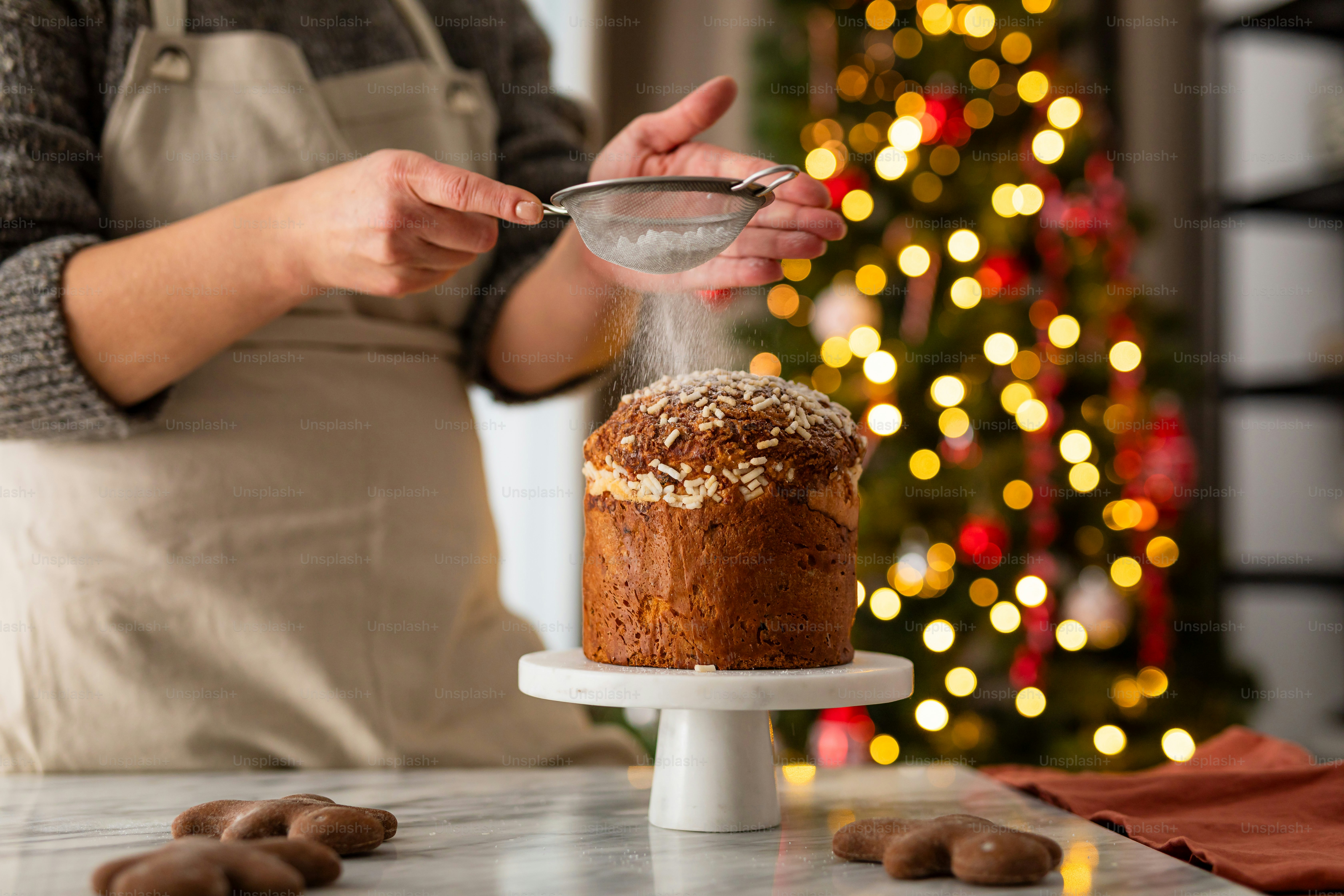 Una donna in grembiule sta cospargendo la glassa su una torta