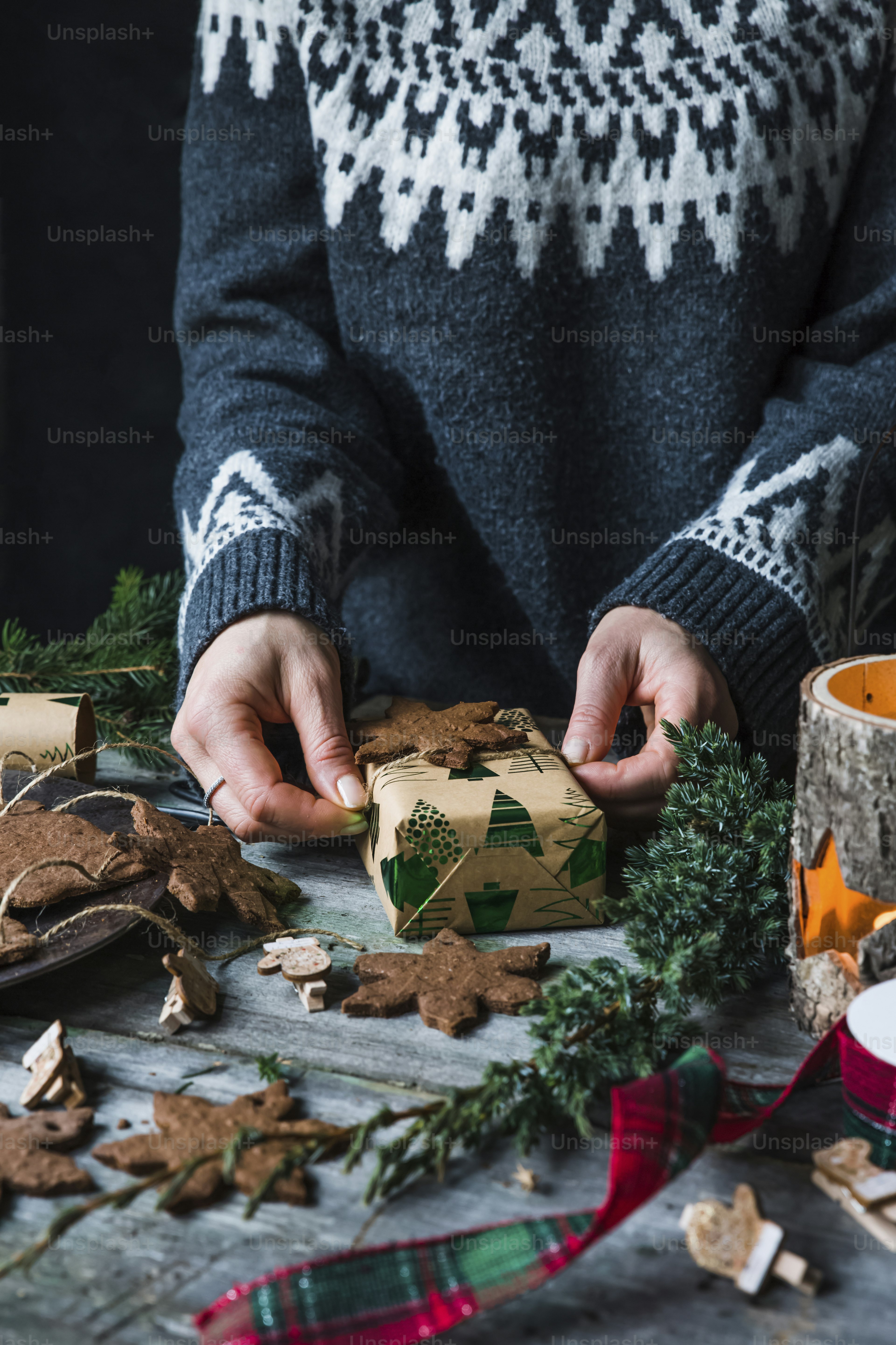 A person is decorating a small christmas tree