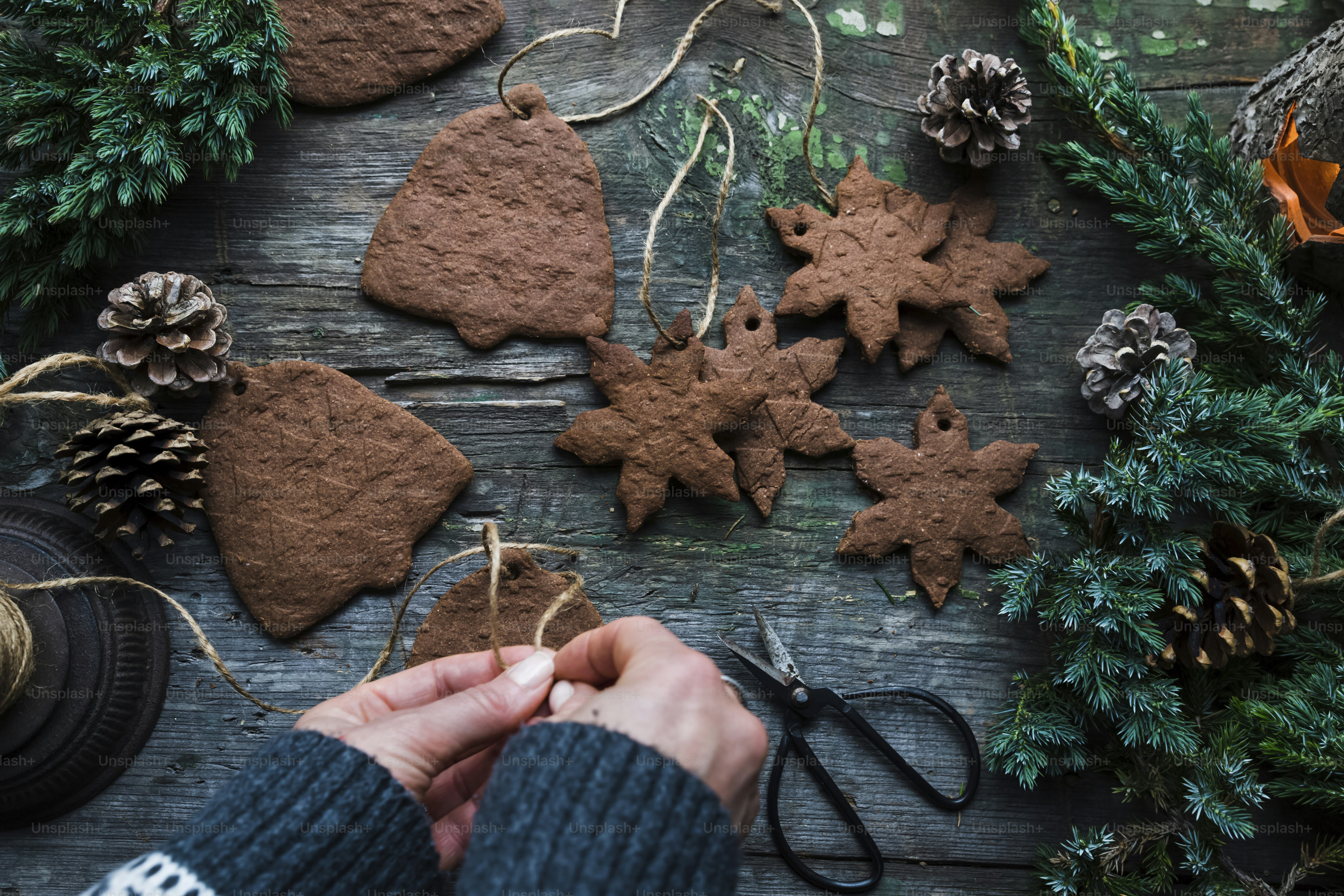 A person is decorating christmas cookies on a table