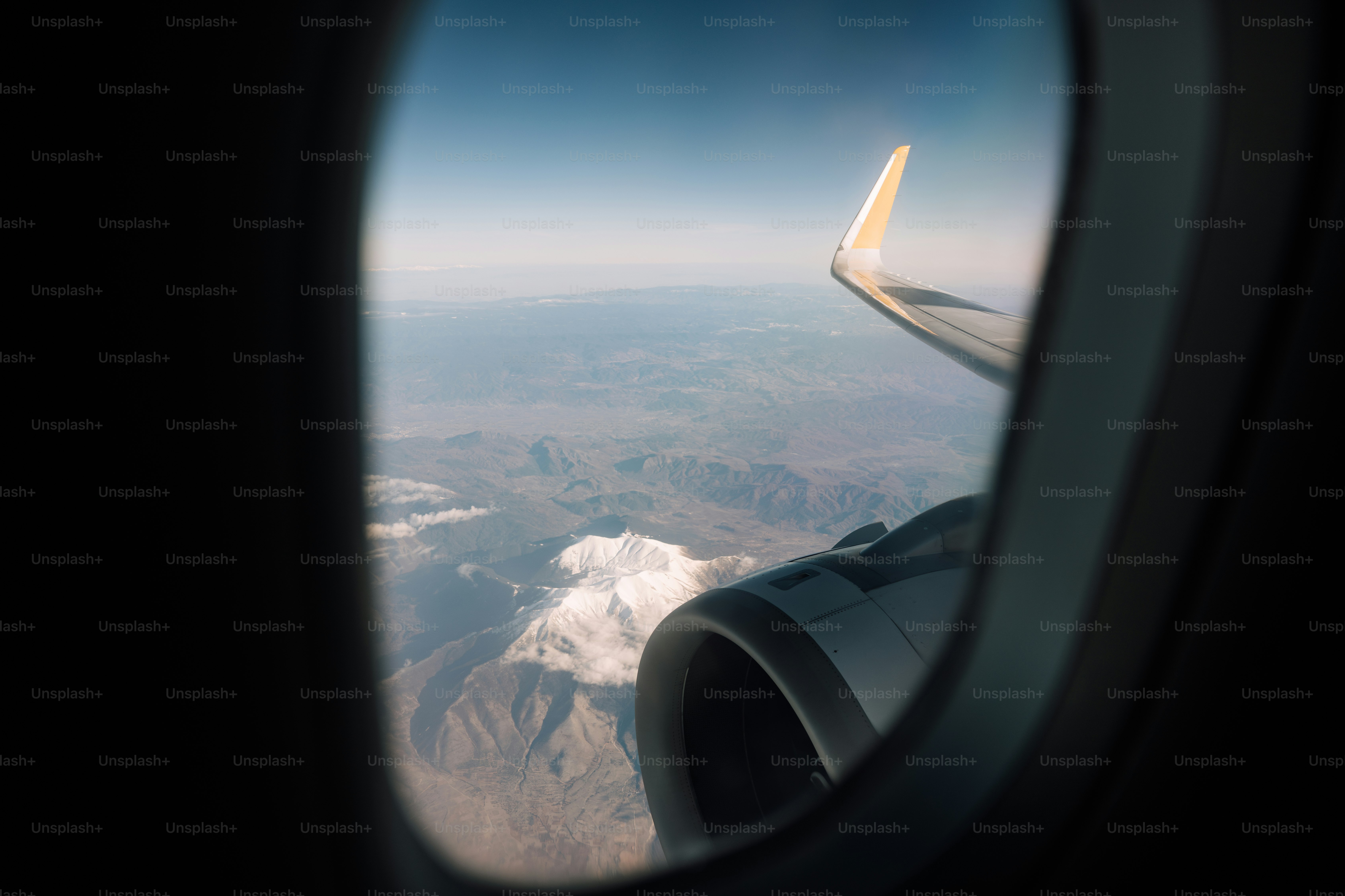 Ein Flugzeugfenster mit Blick auf die Berge