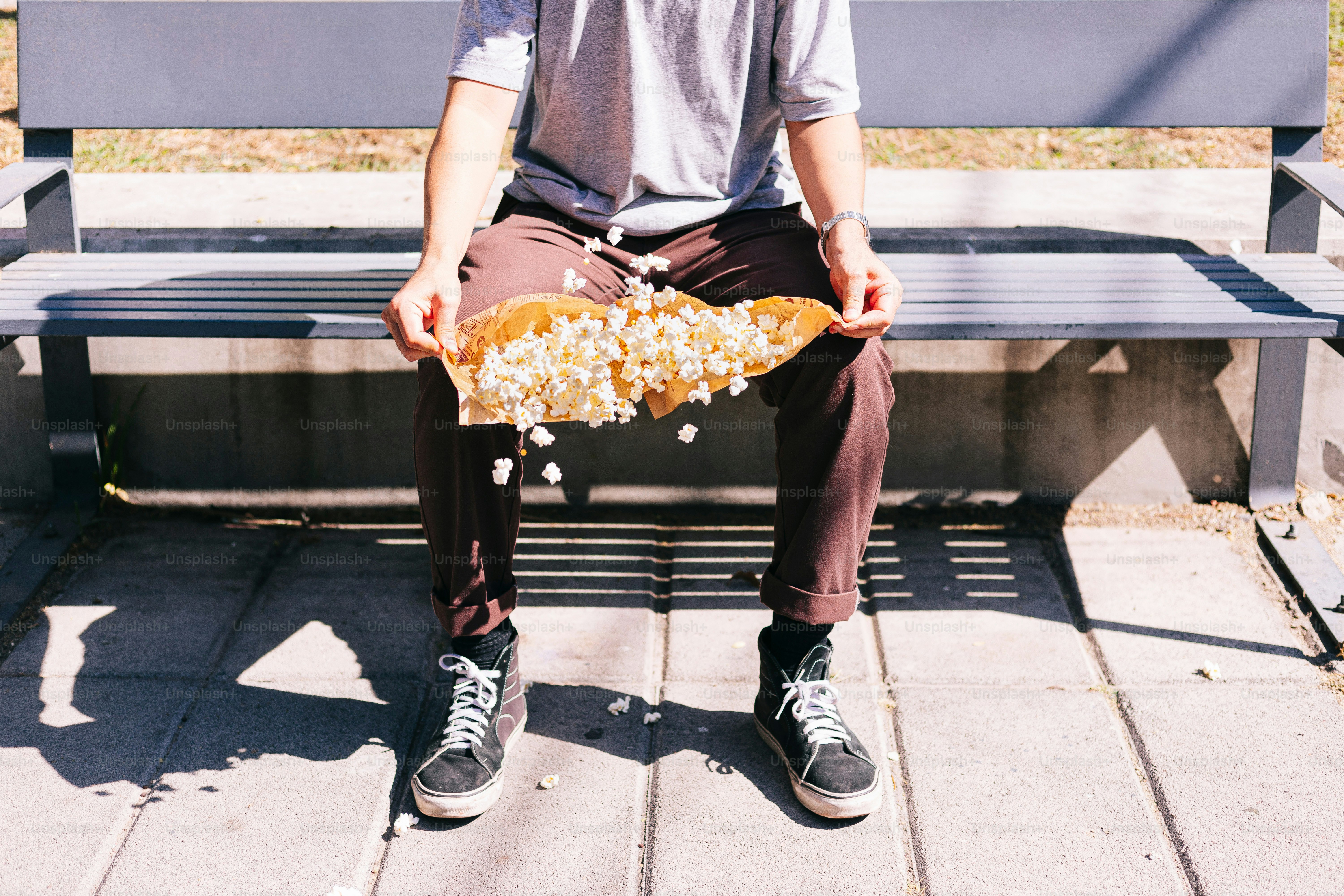A man sitting on a bench holding a skateboard