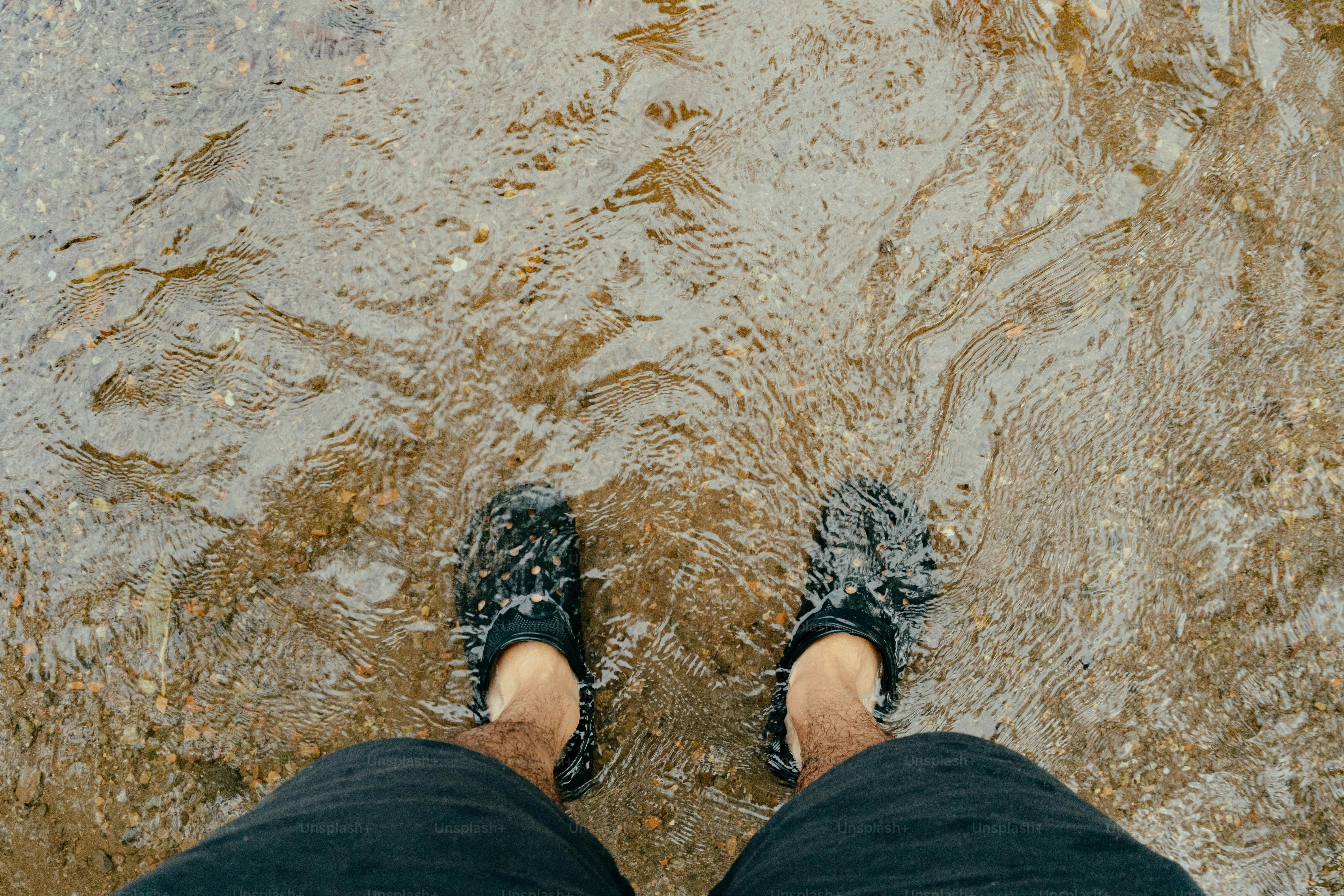 Une personne debout dans l’eau peu profonde, les pieds dans l’eau