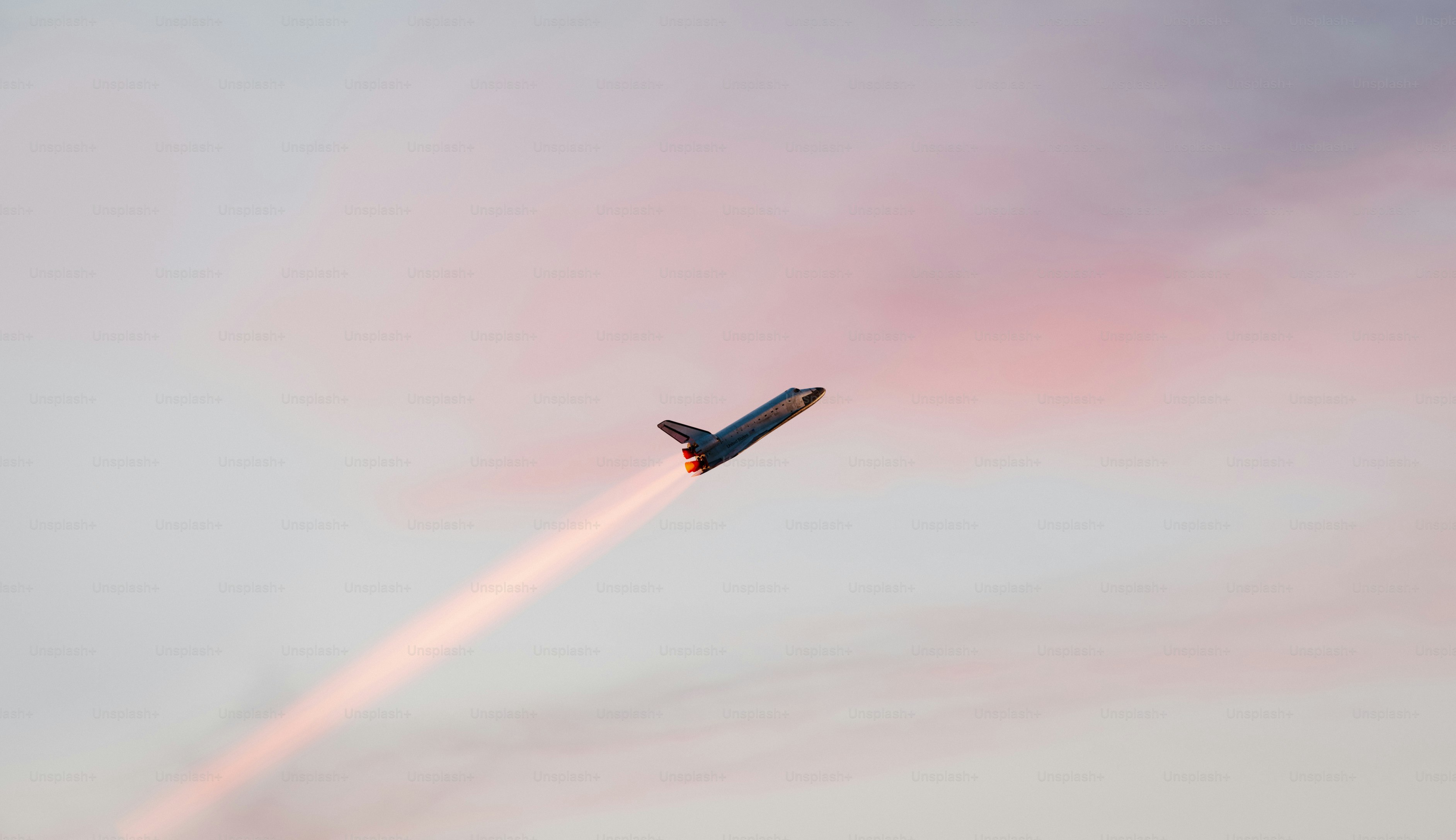 A jet flying in the sky with a trail of smoke behind it