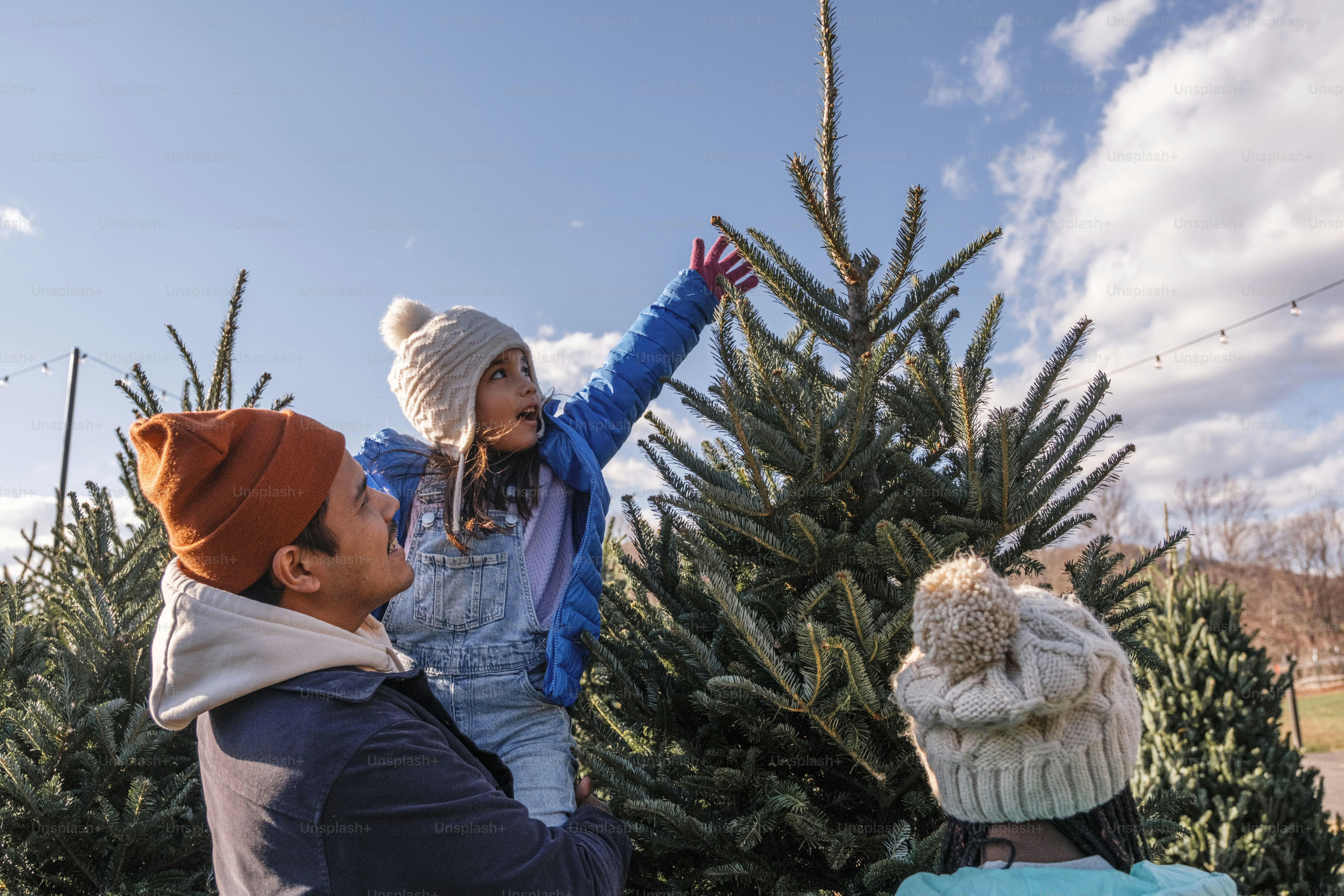 A group of people standing around a christmas tree
