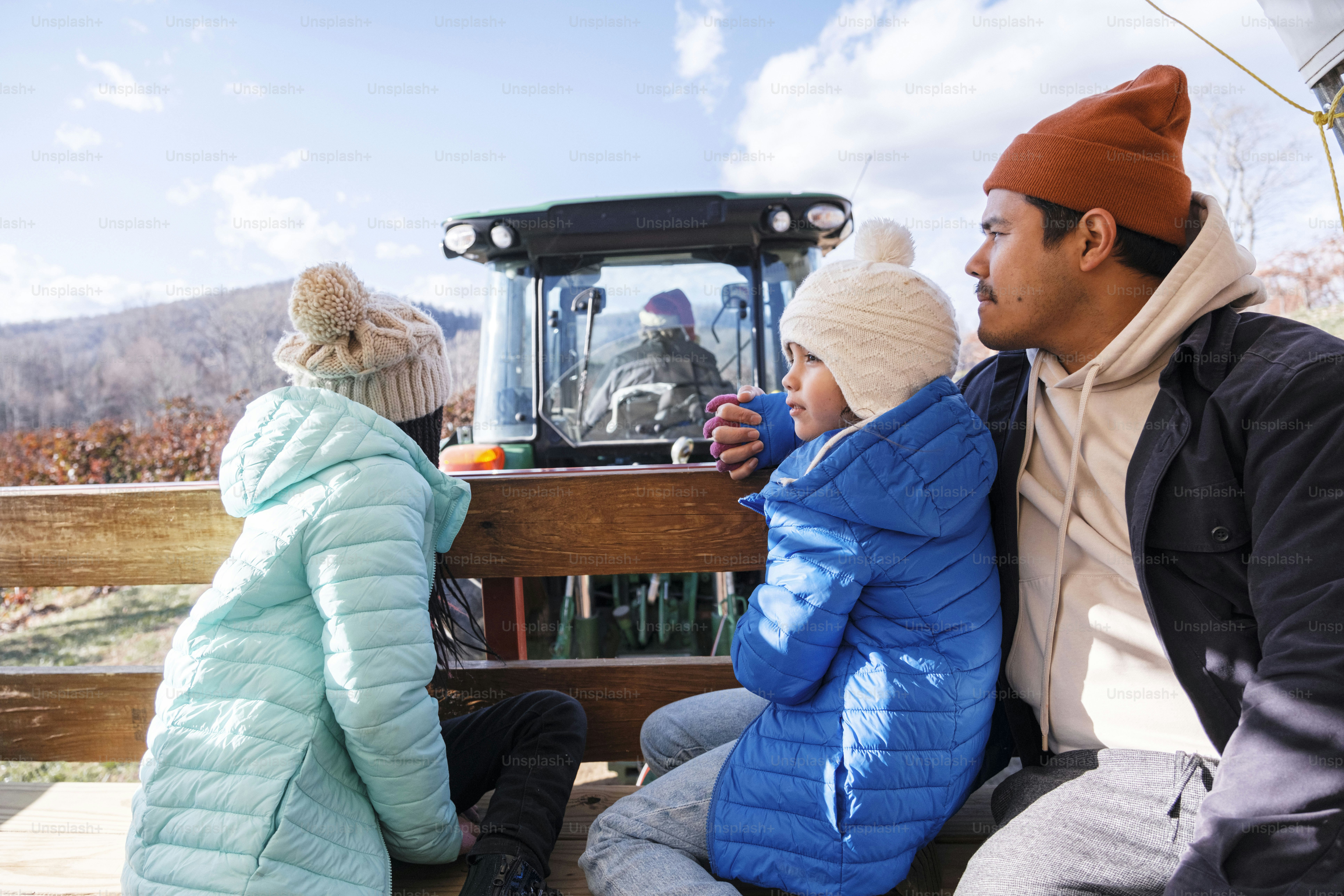A man and two children sitting on a bench
