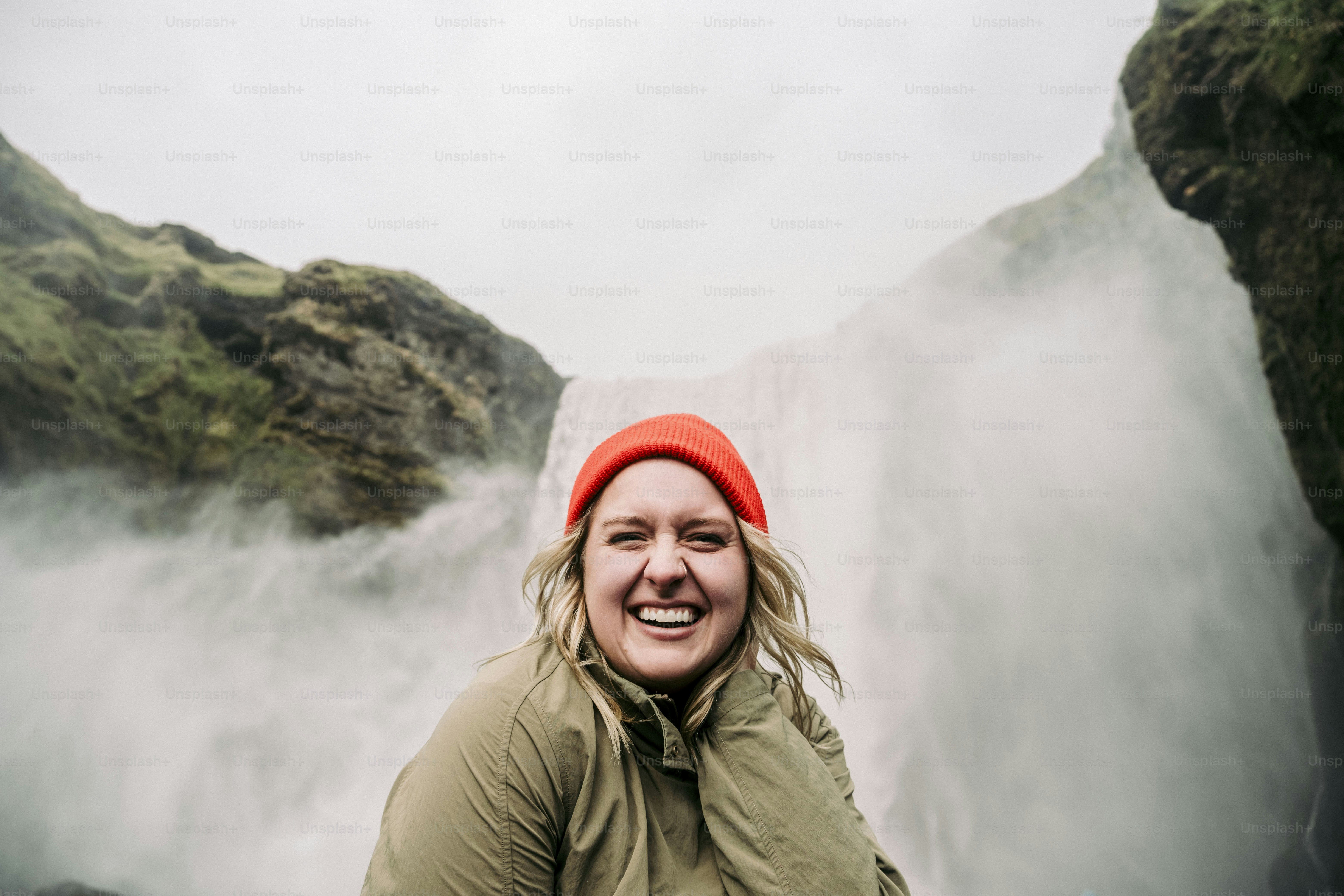 Uma mulher em pé na frente de uma cachoeira