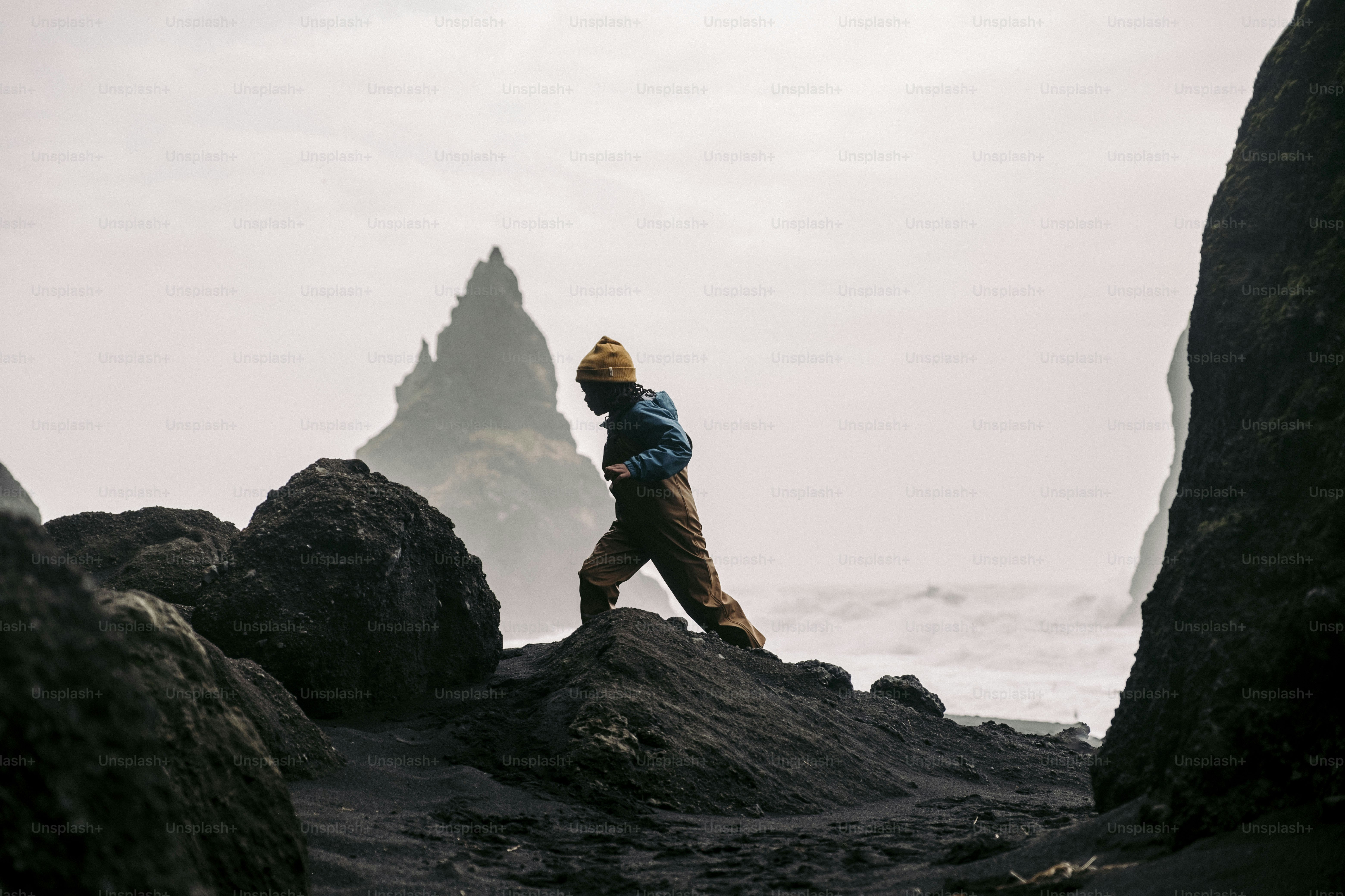 A person standing on a rock near the ocean