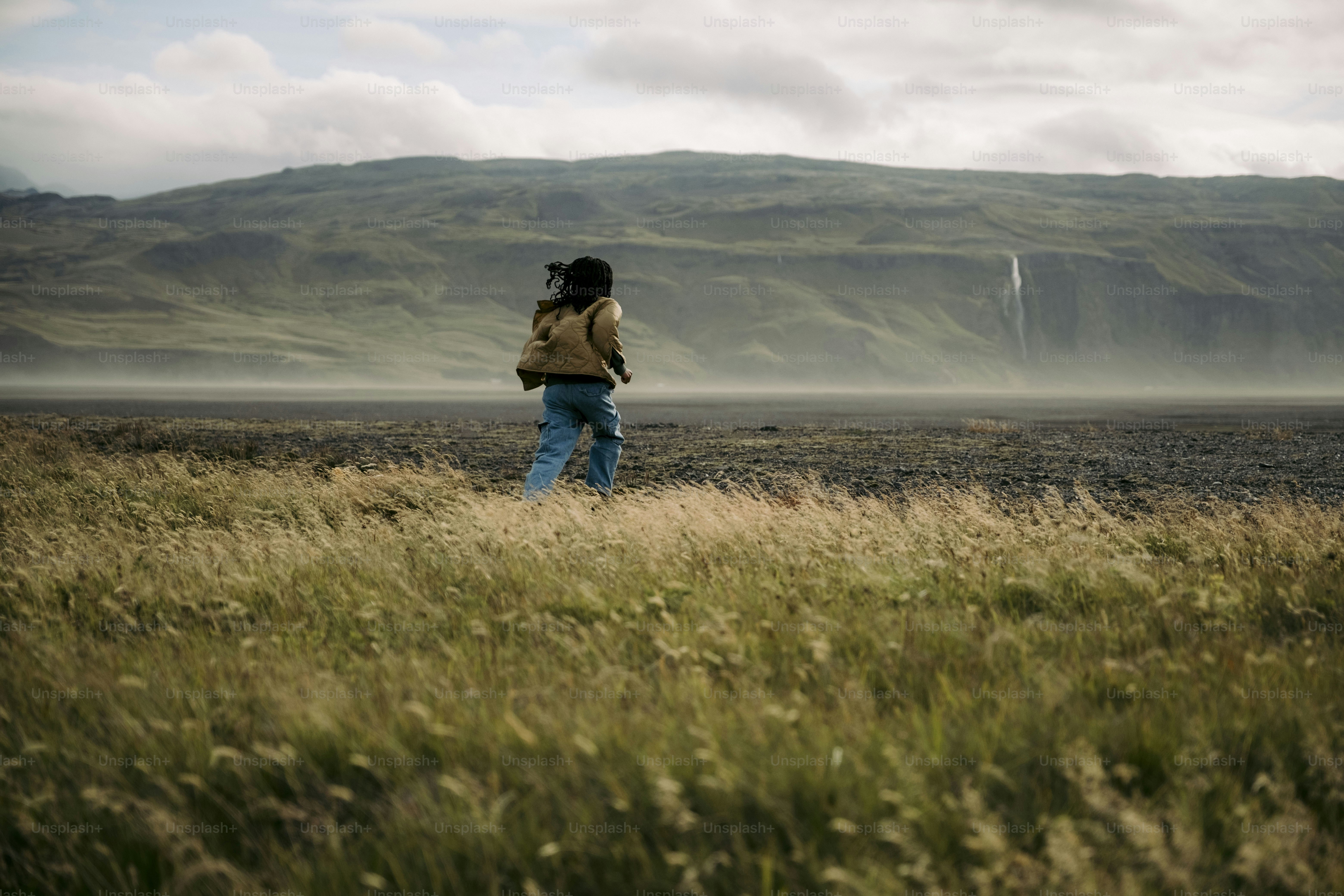 A person standing in a field with a backpack