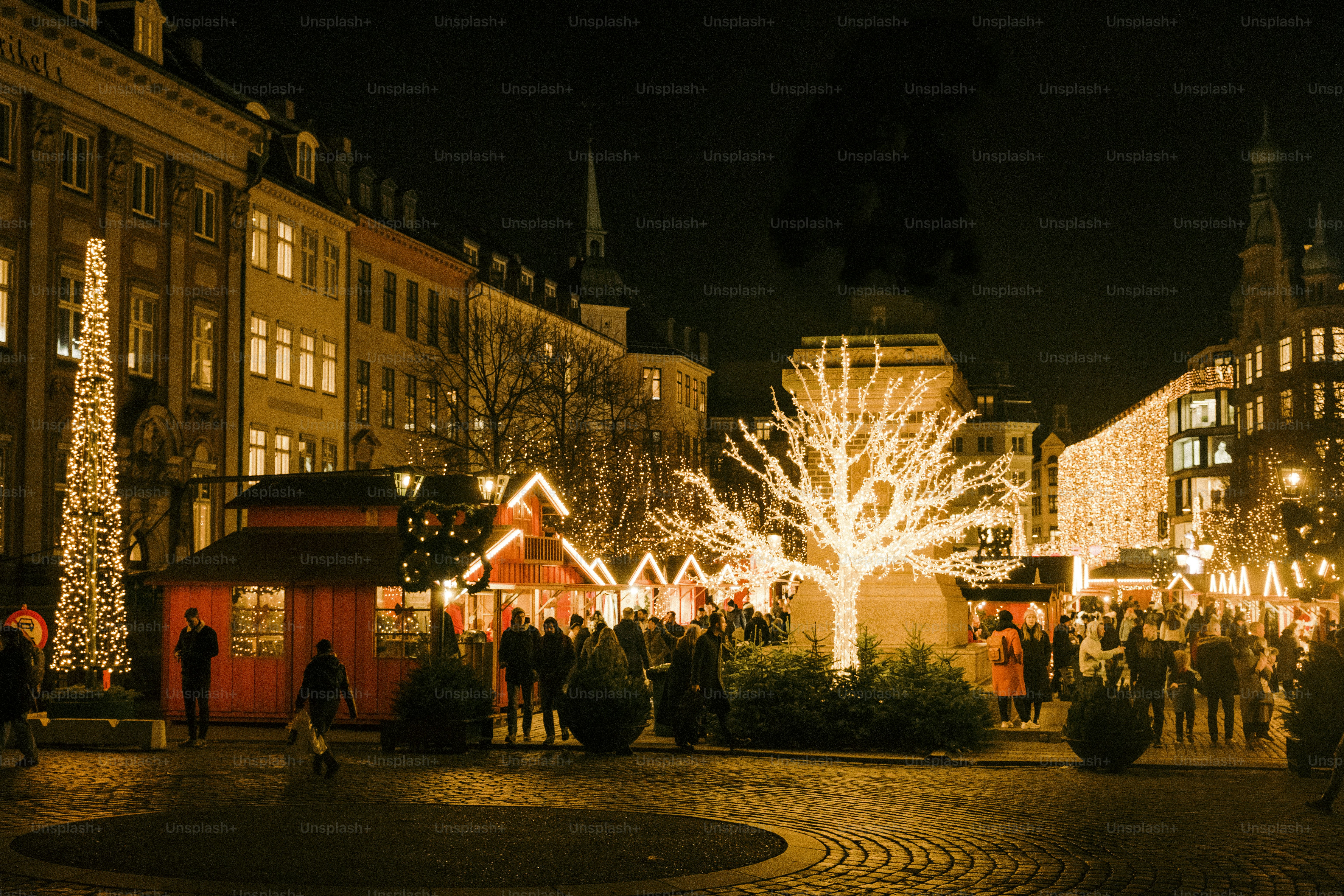 A group of people standing around a christmas tree