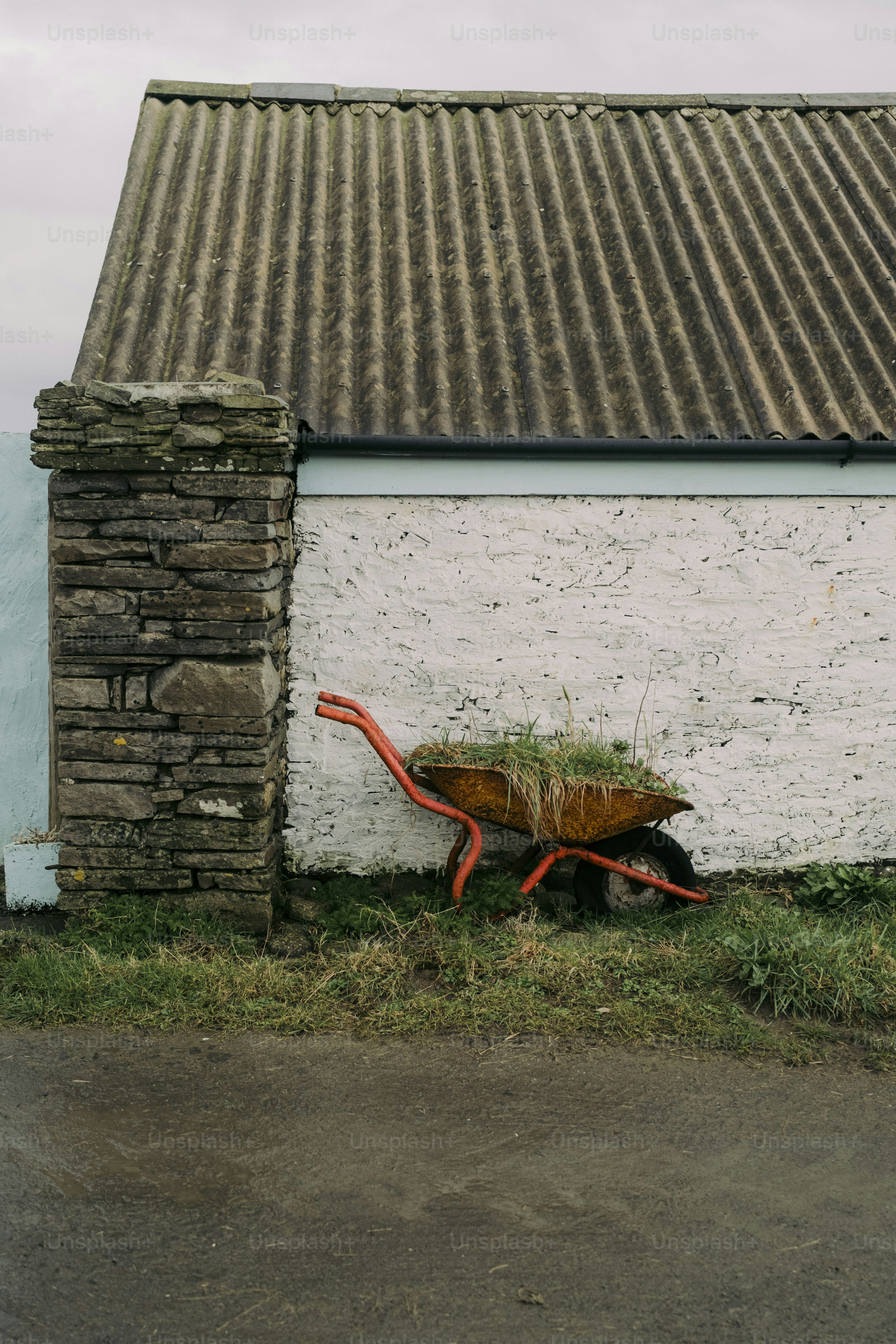 A building with a wheelbarrow in front of it
