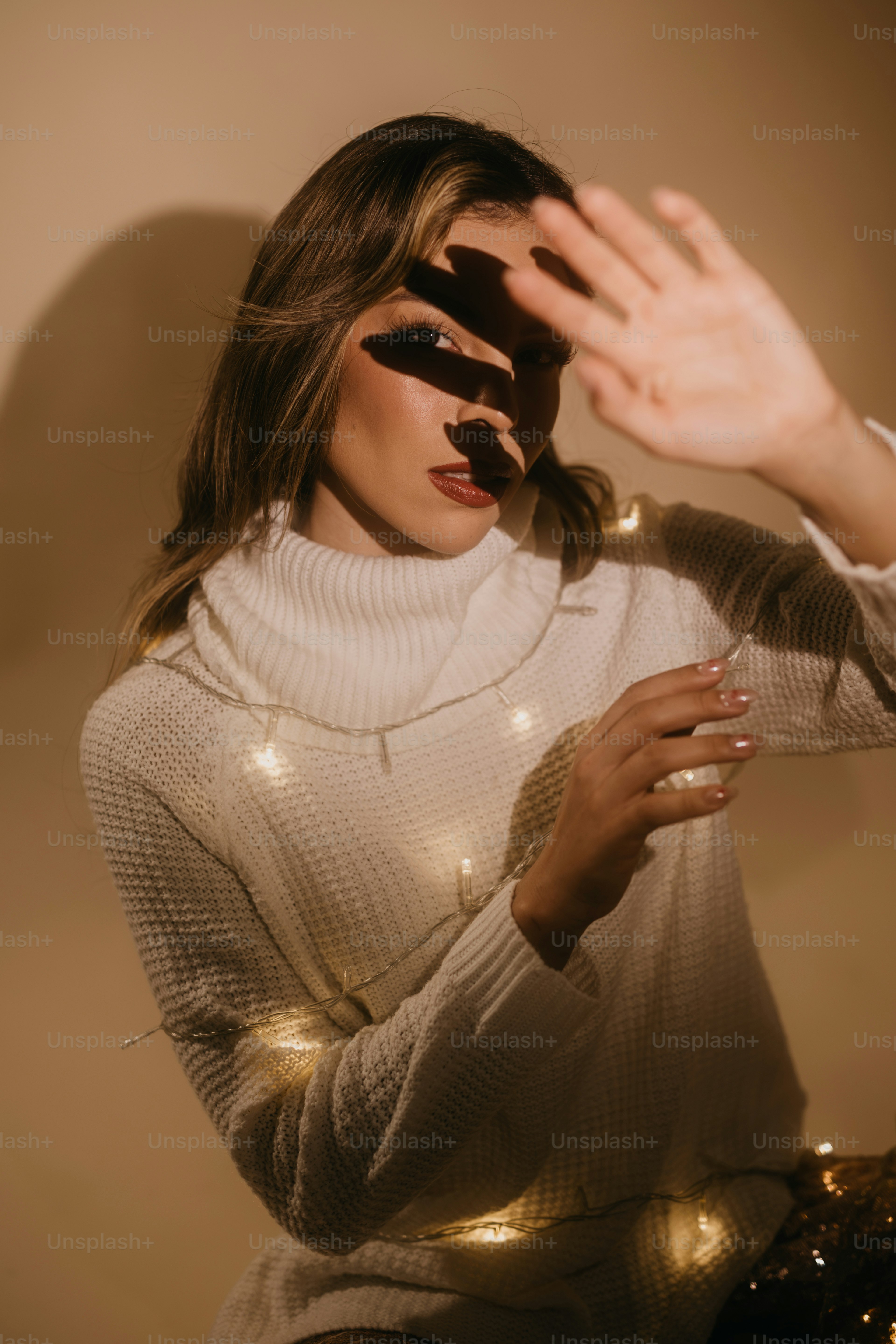 A woman in a white sweater is holding her hands up