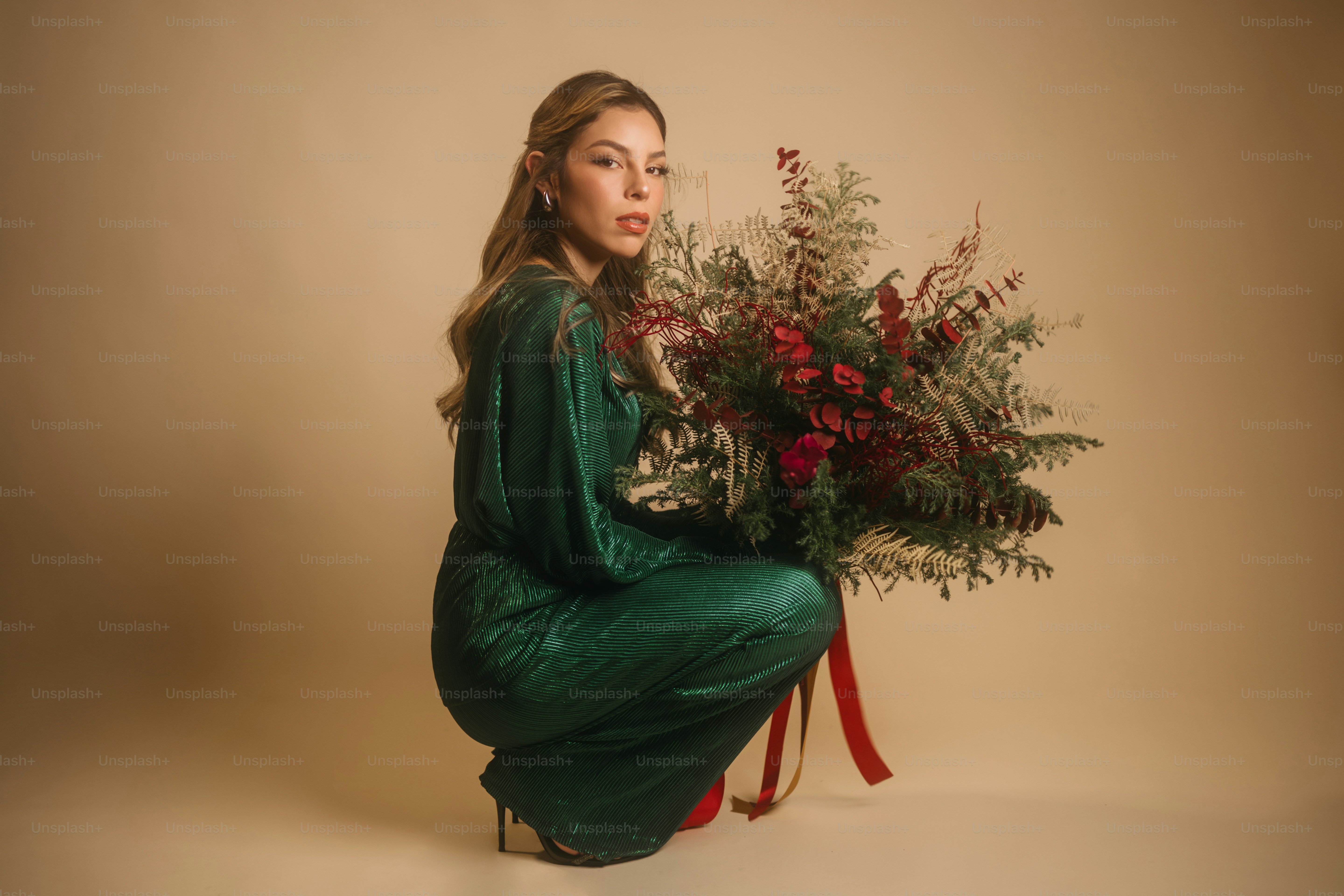A woman in a green dress holding a bouquet of flowers