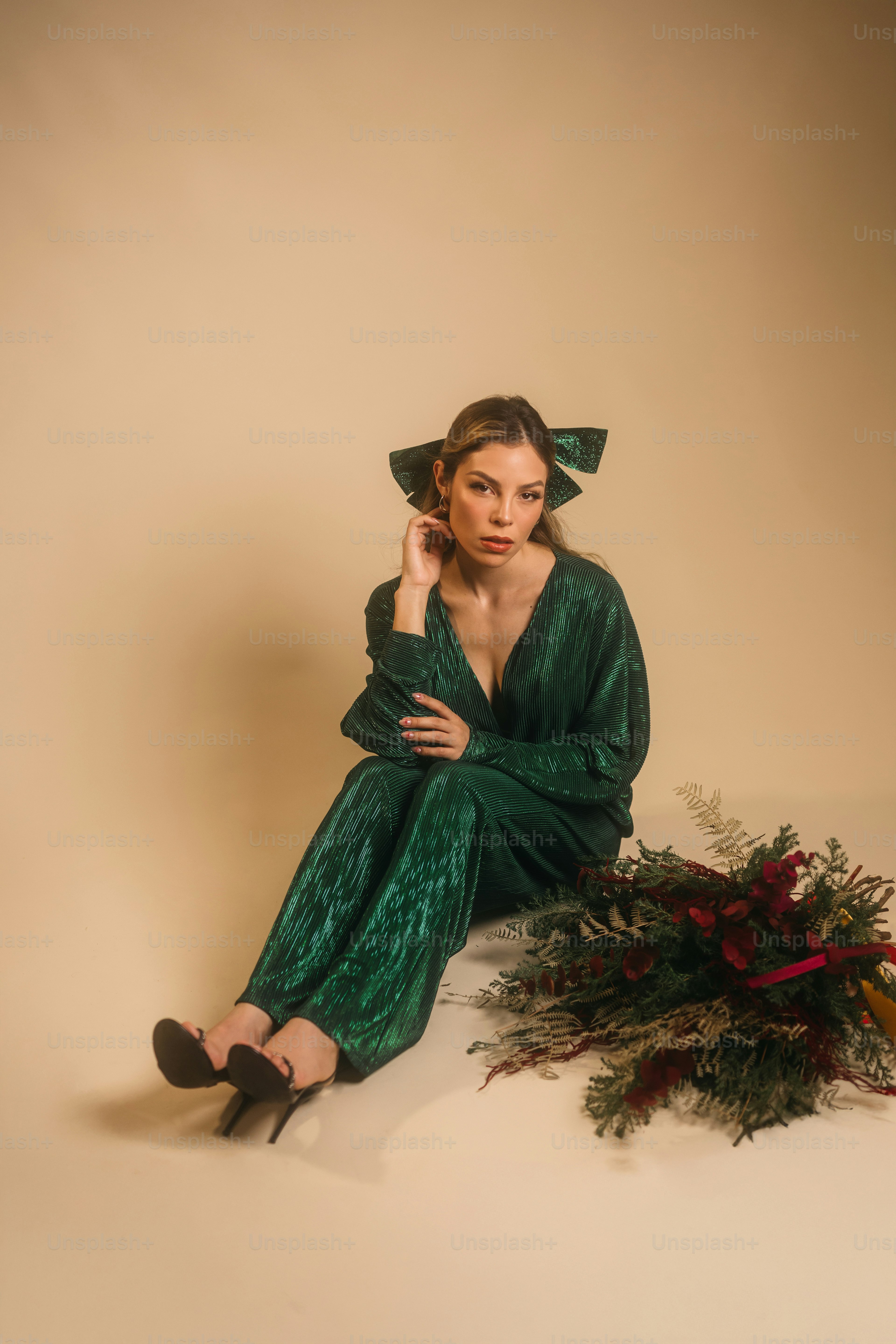 A woman in a green dress sitting next to a plant