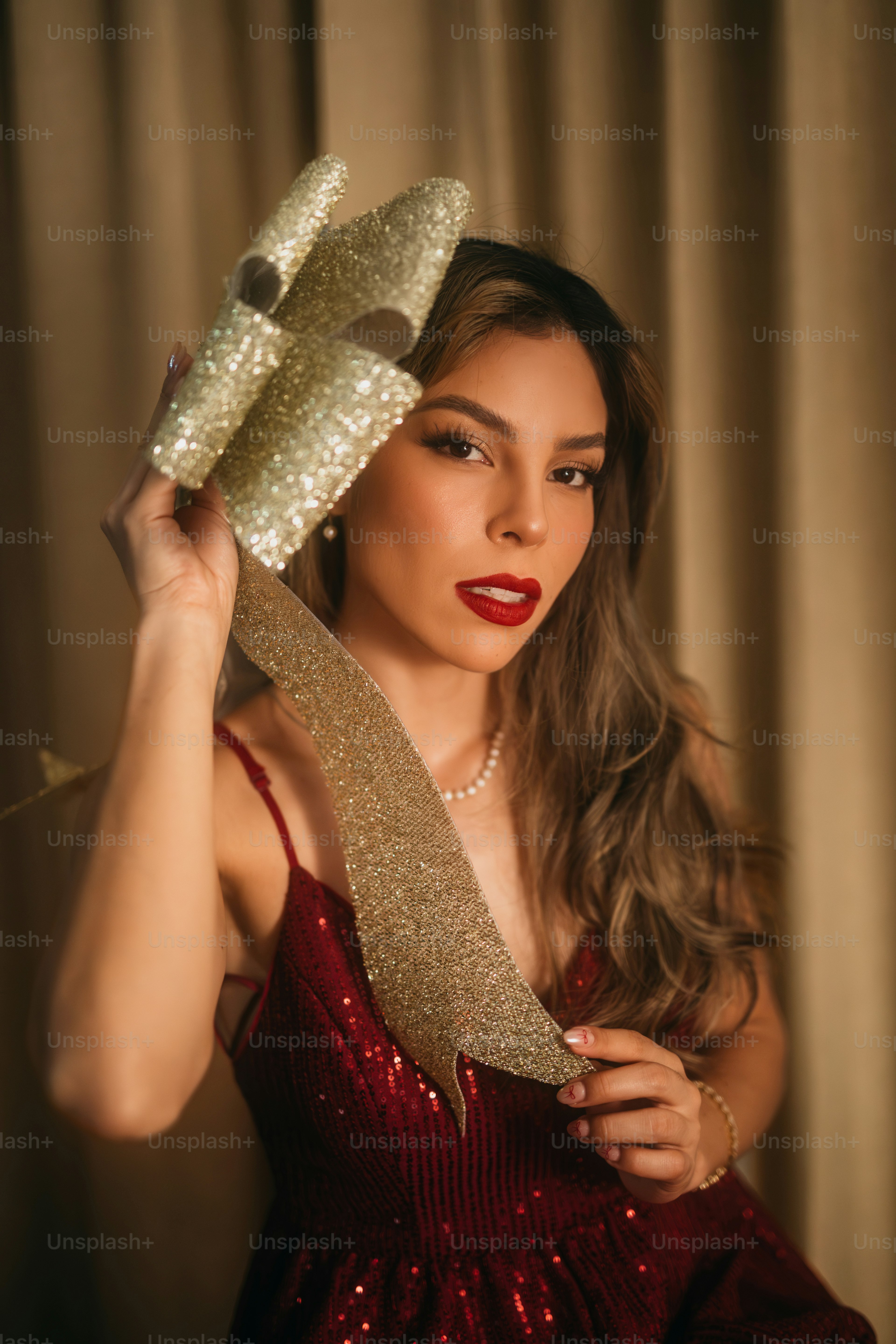 A woman in a red dress holding a pair of shoes