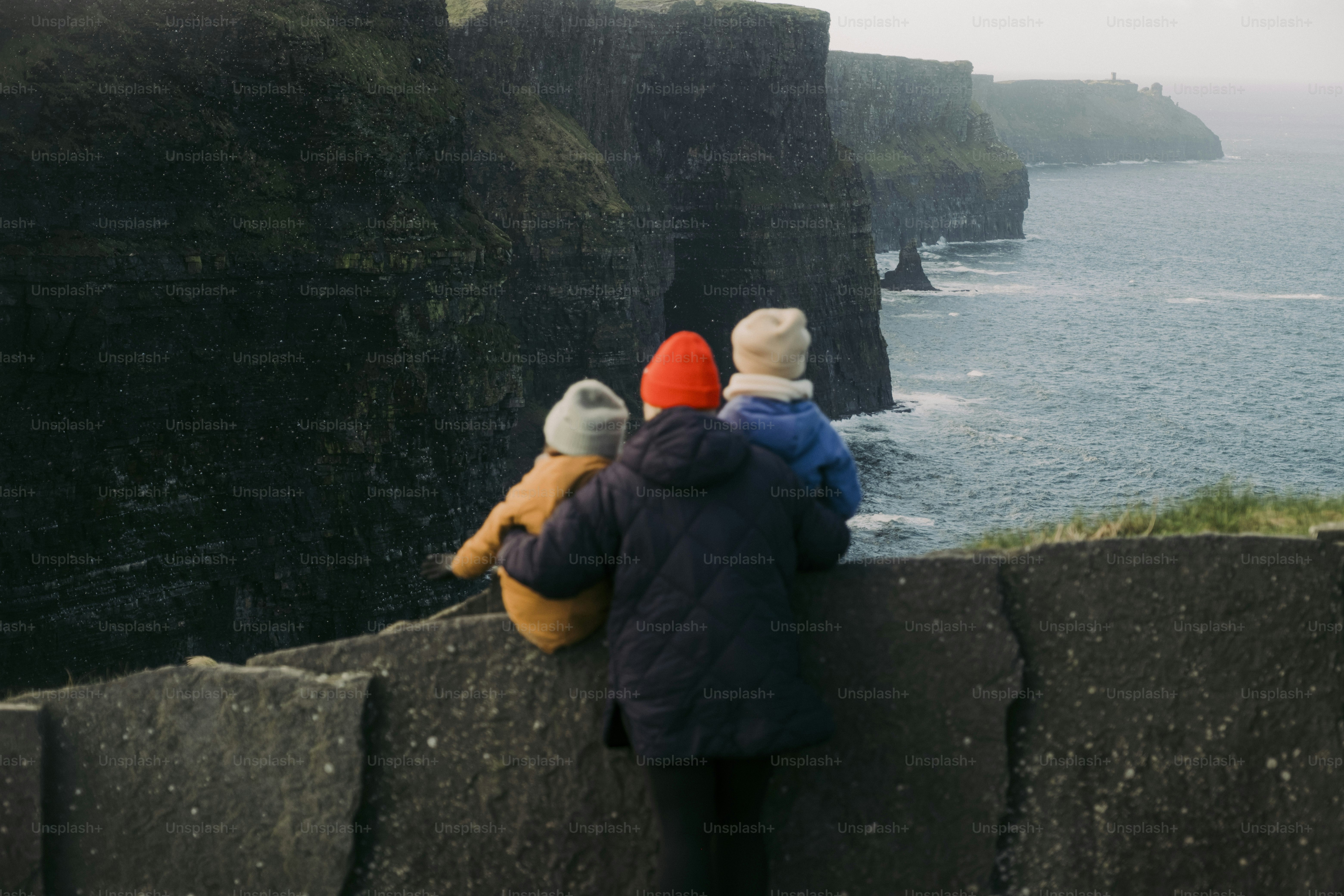 Um casal de pessoas em pé no topo de um penhasco