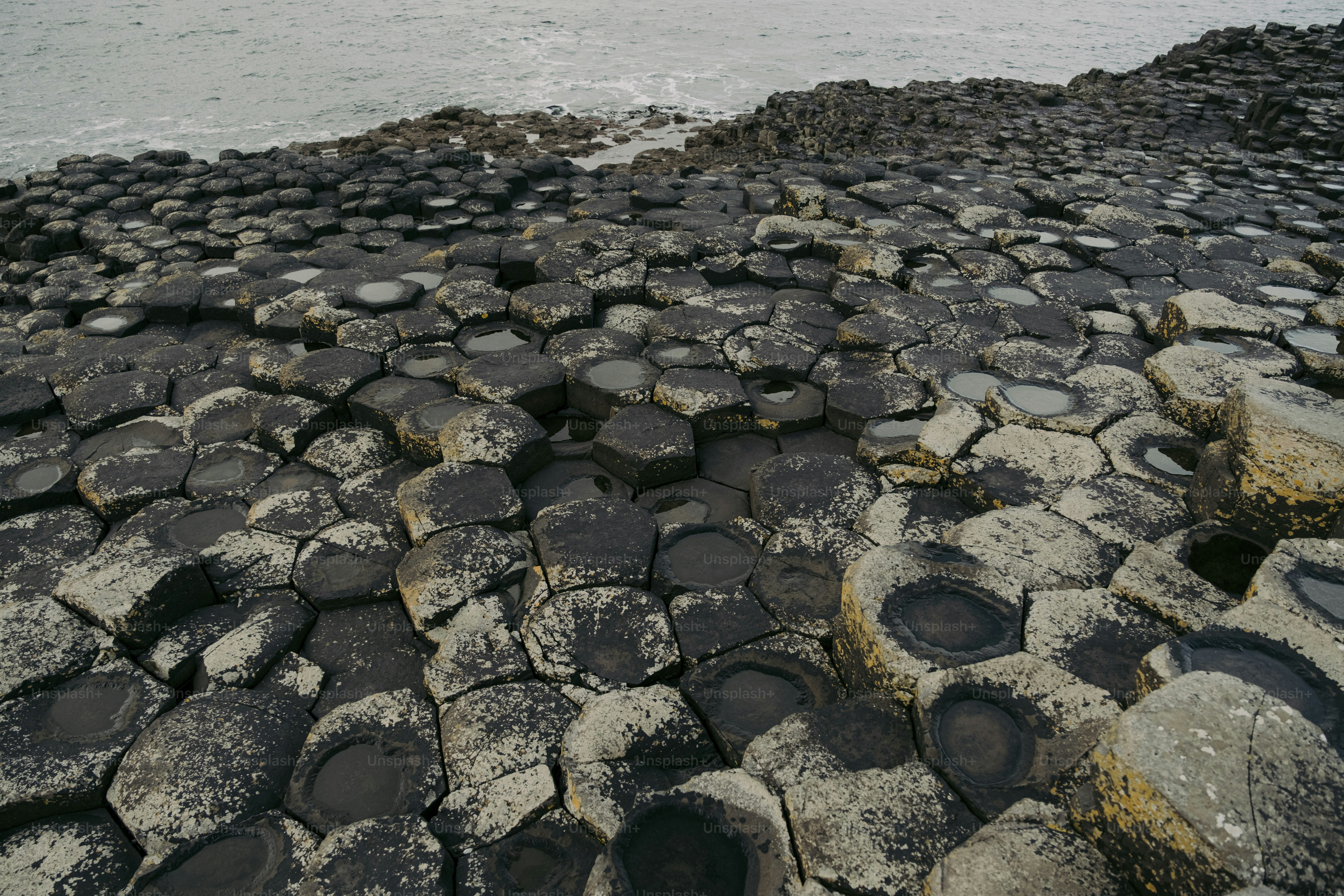 Uma praia rochosa com um corpo de água ao fundo