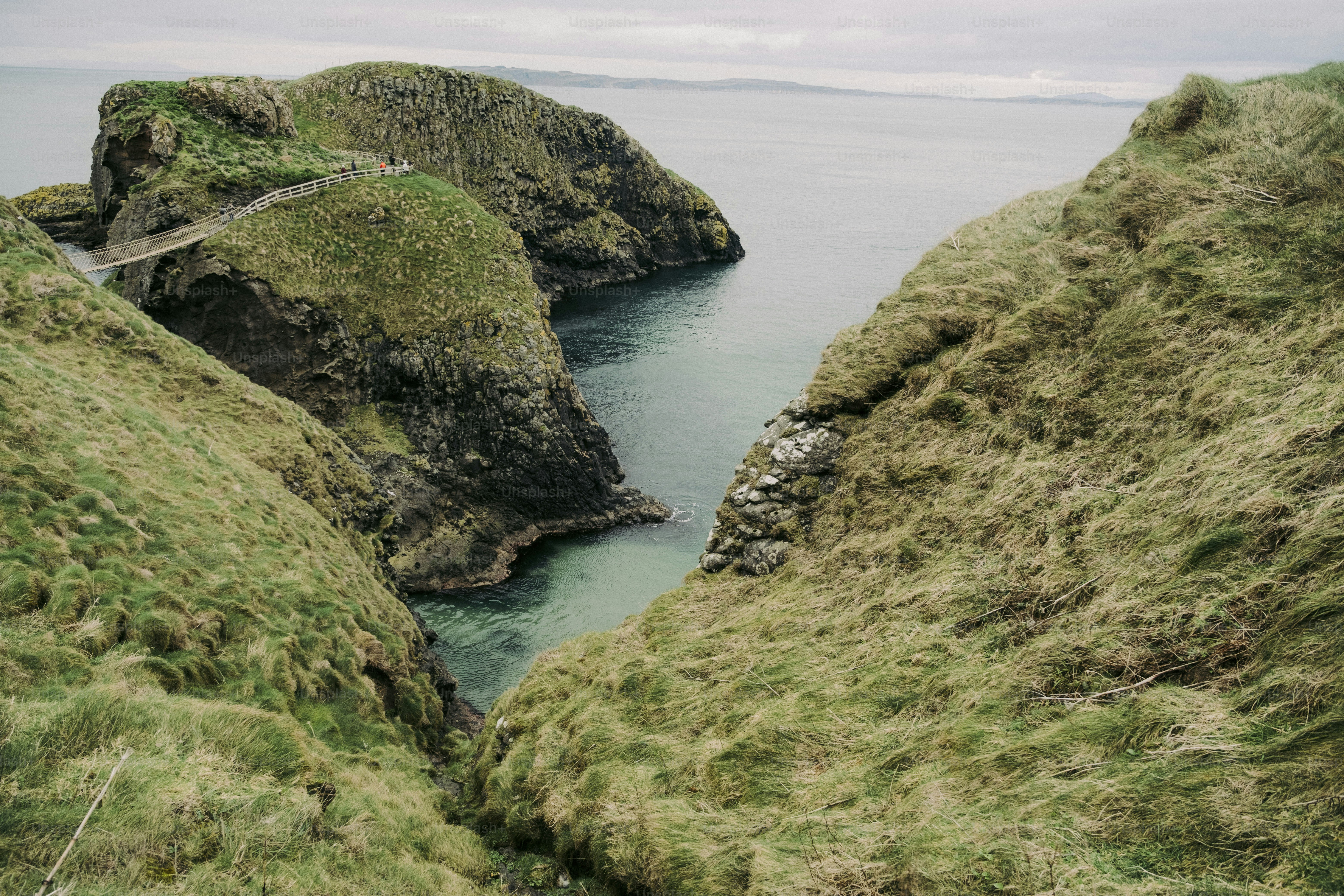 A couple of large rocks sitting on top of a lush green hillside