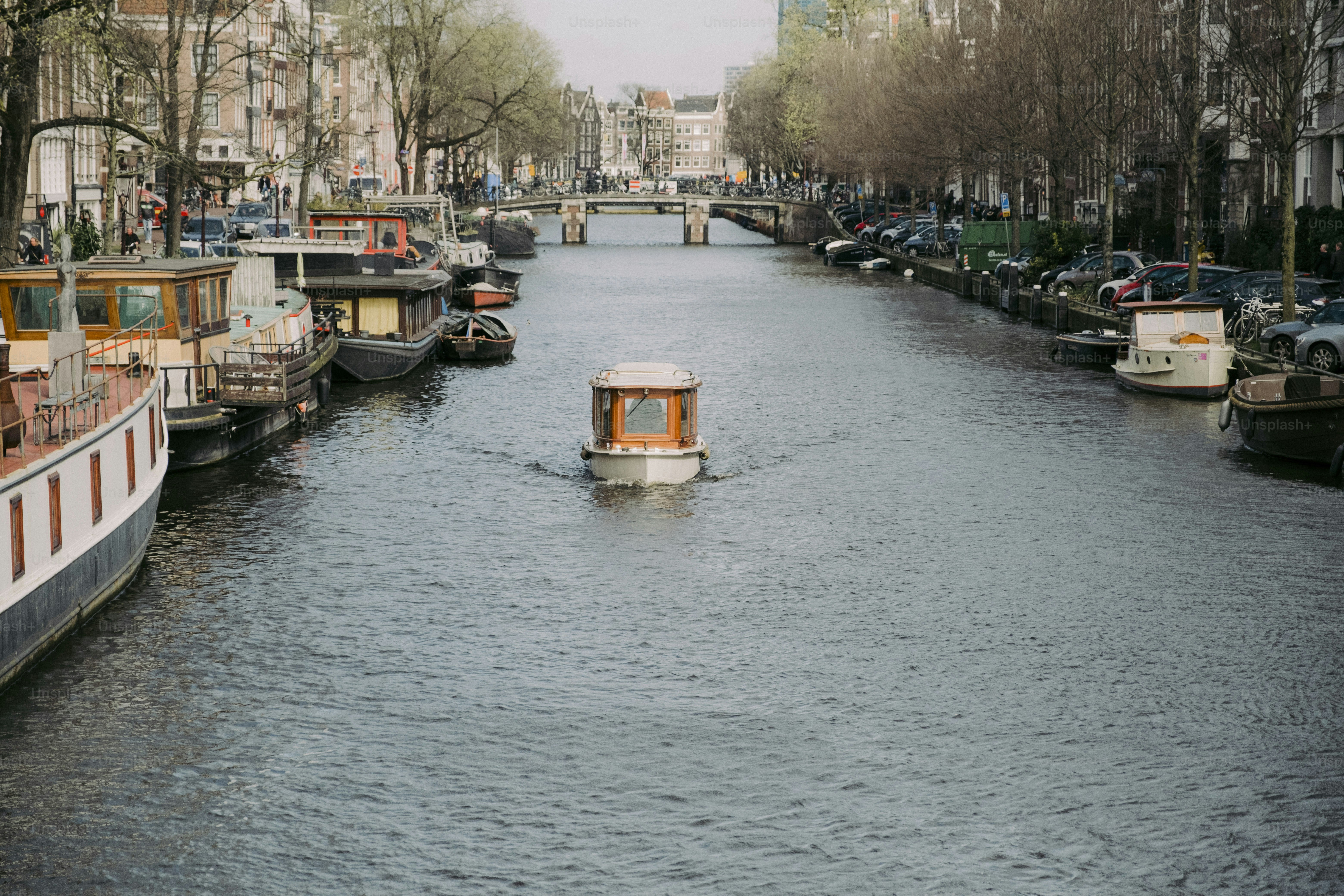 A boat traveling down a river next to tall buildings