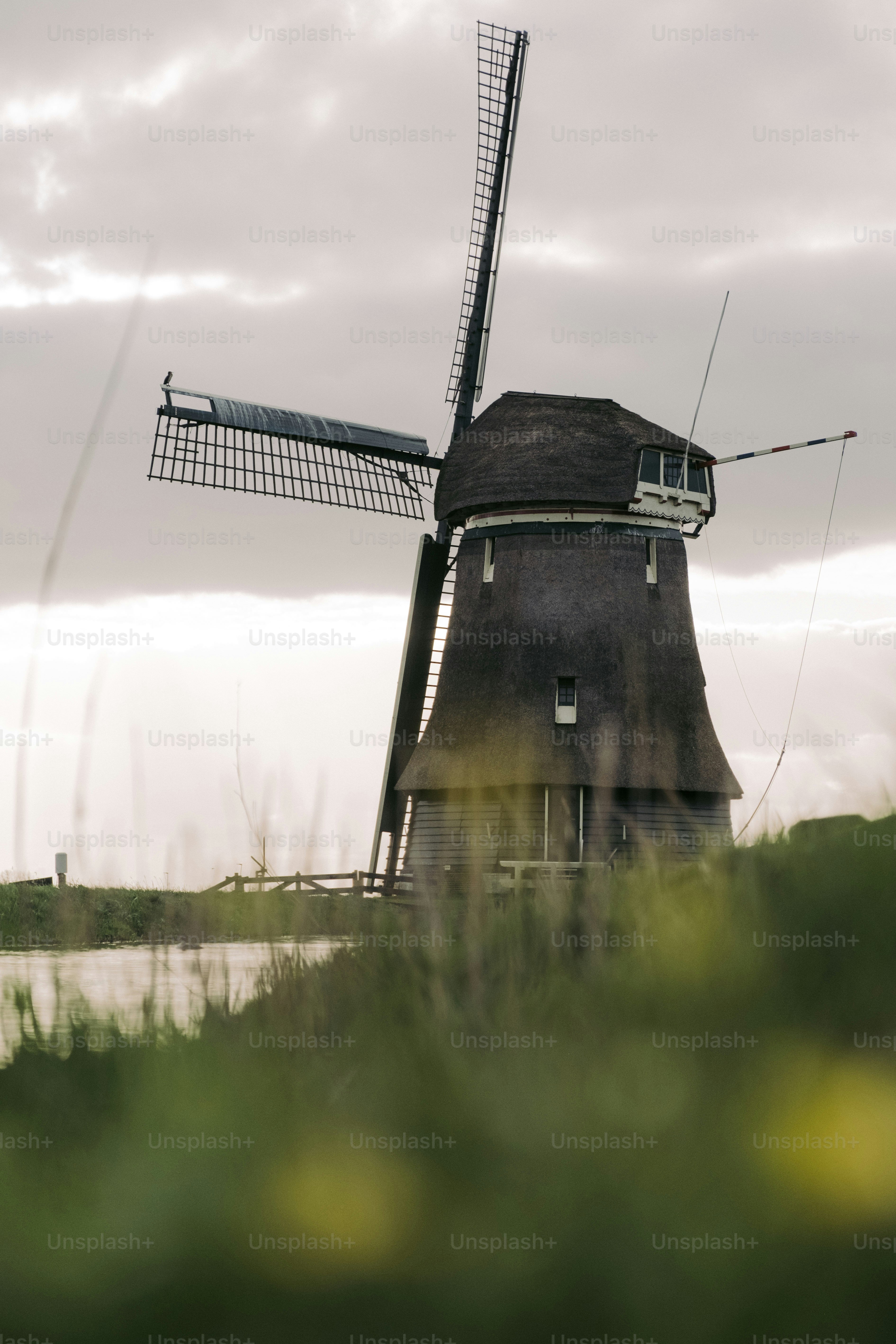 A windmill sitting on top of a lush green field