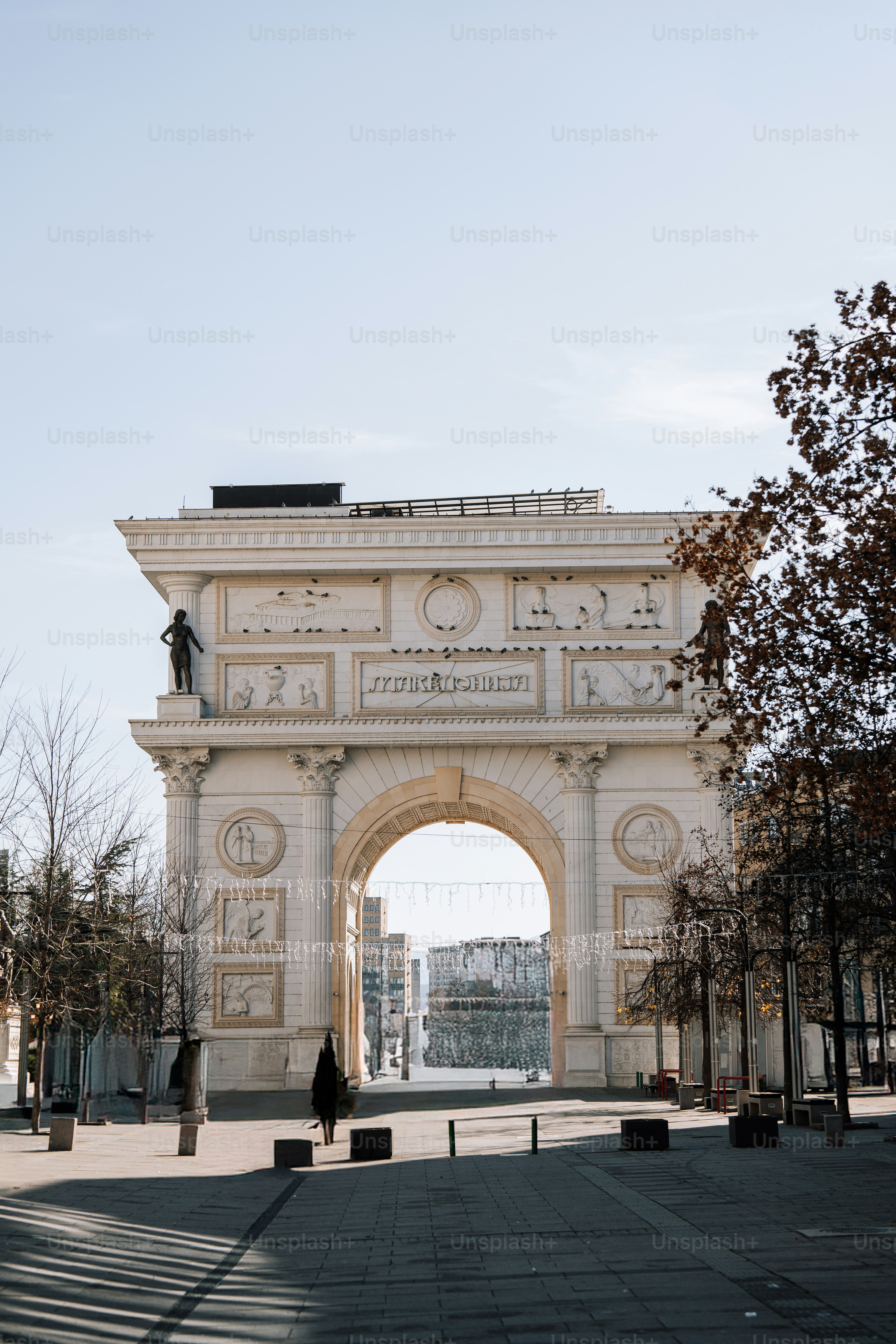 A large white arch in the middle of a park