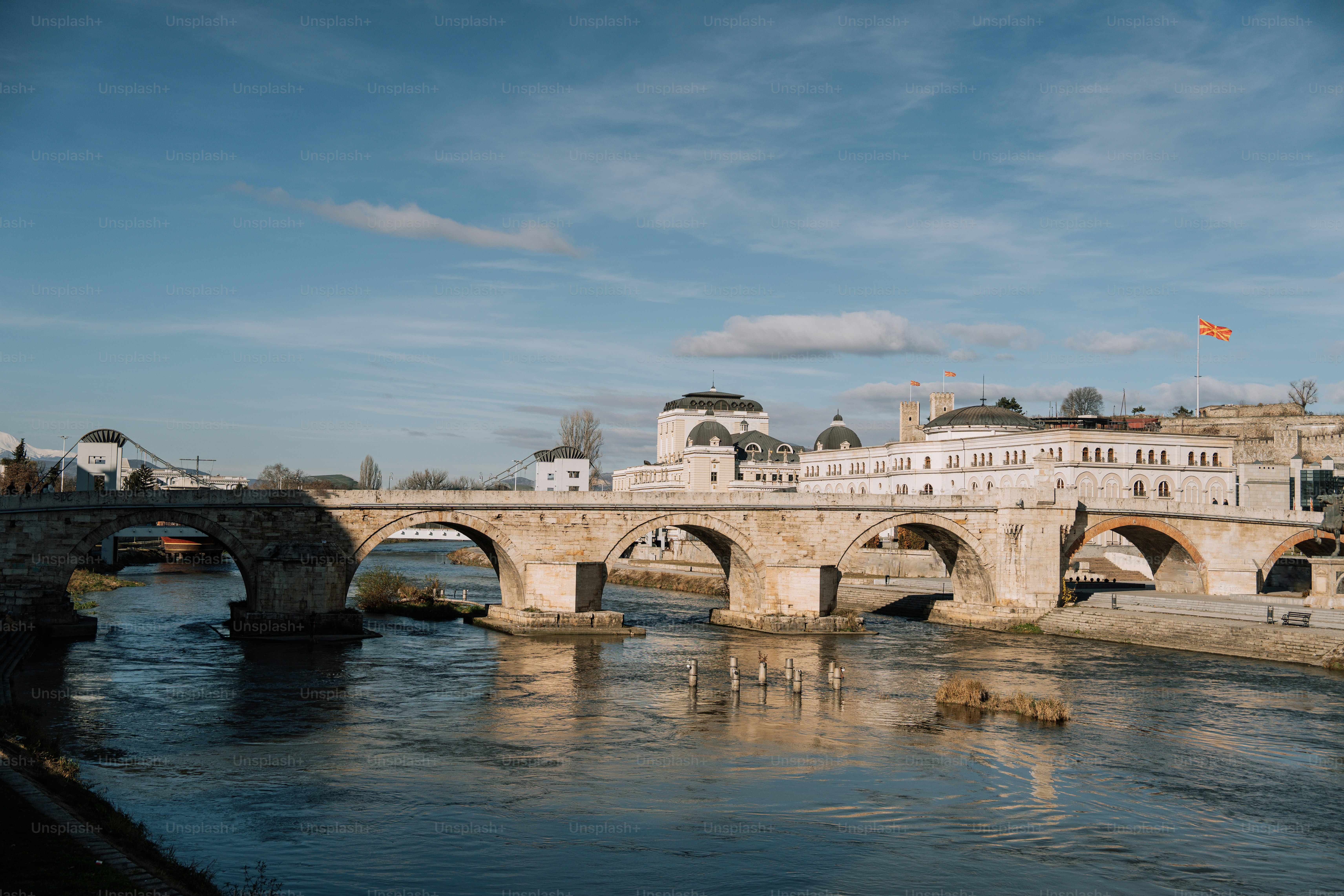 A bridge over a body of water with buildings in the background