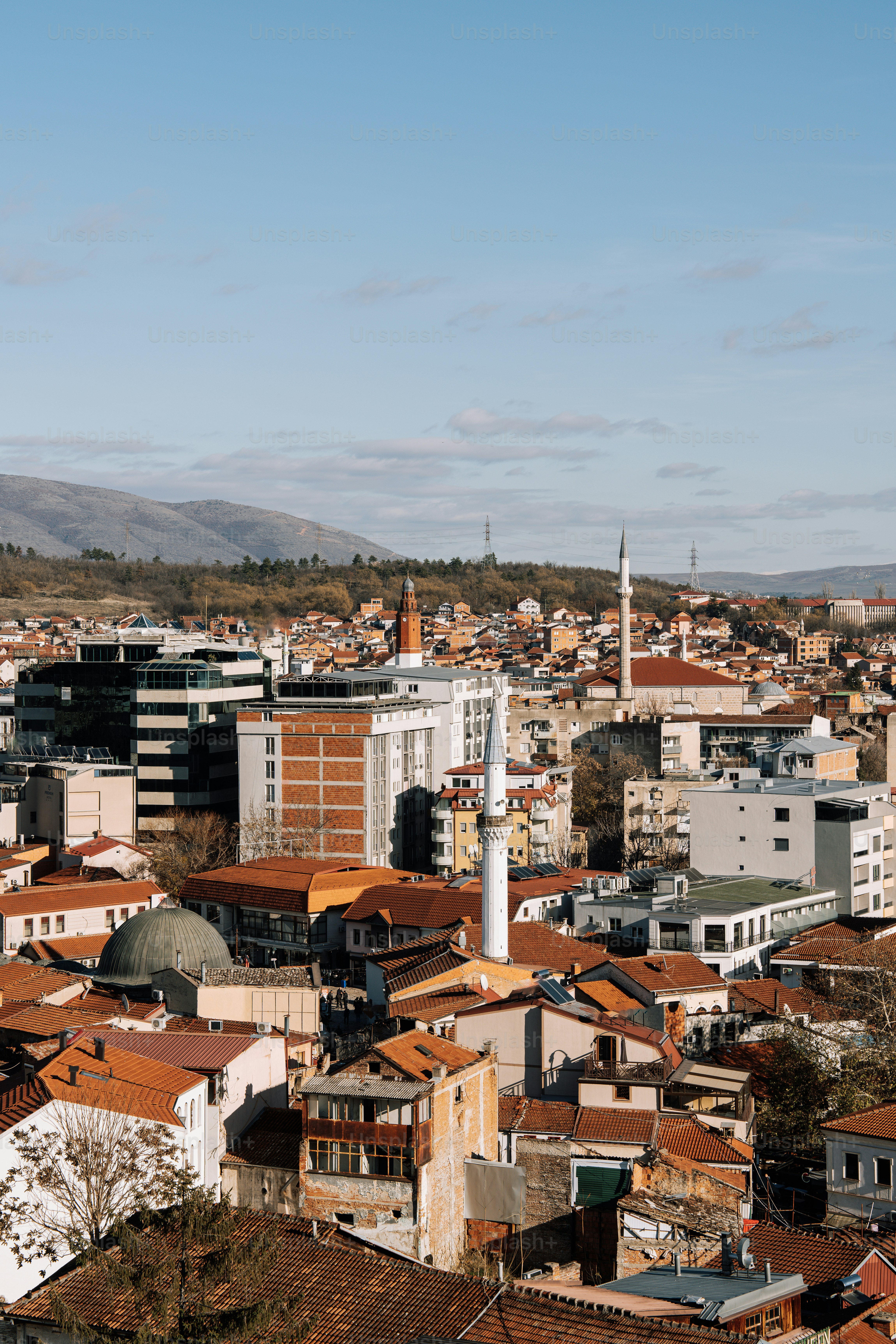 A view of a city with buildings and hills in the background