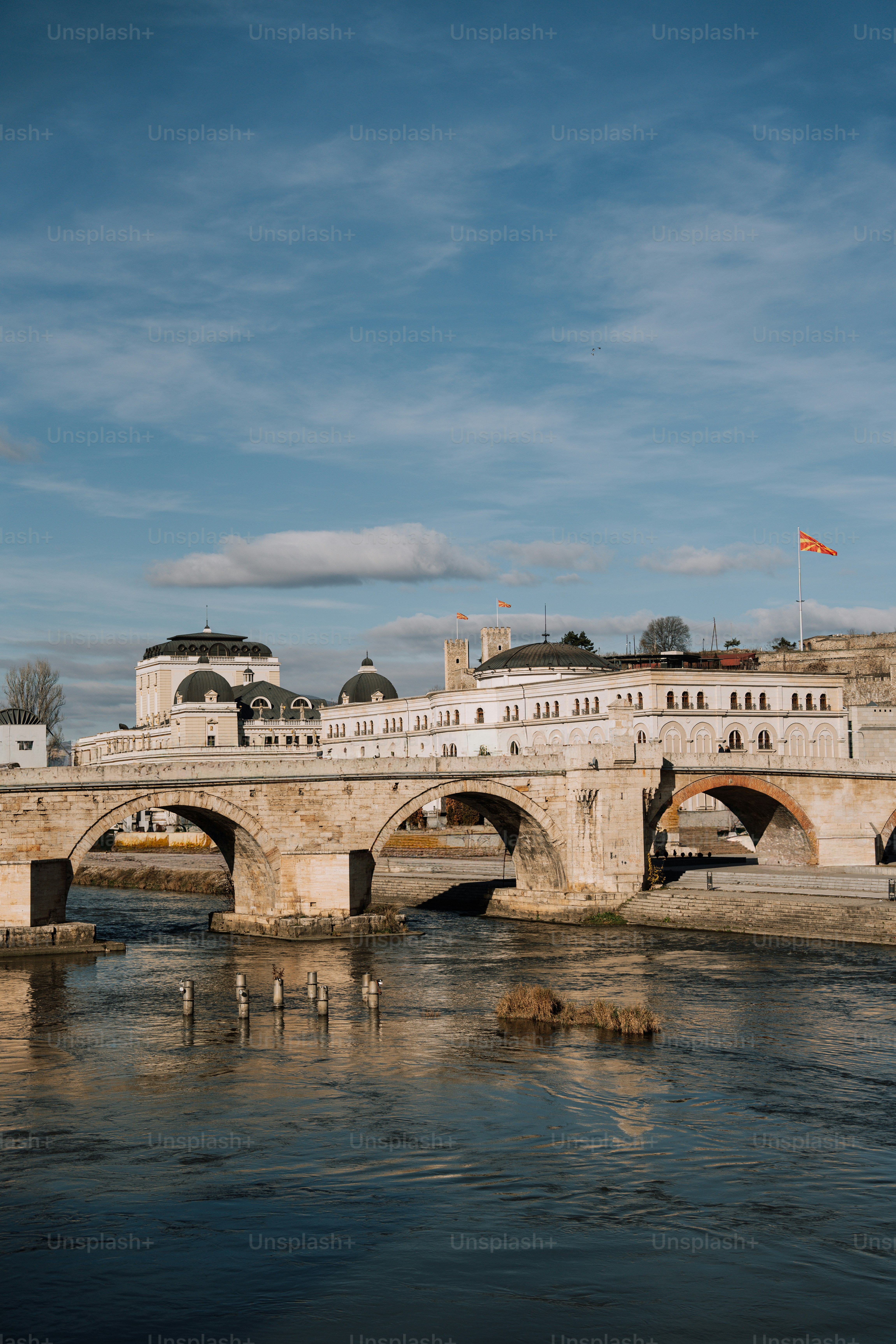 A bridge over a body of water with buildings in the background
